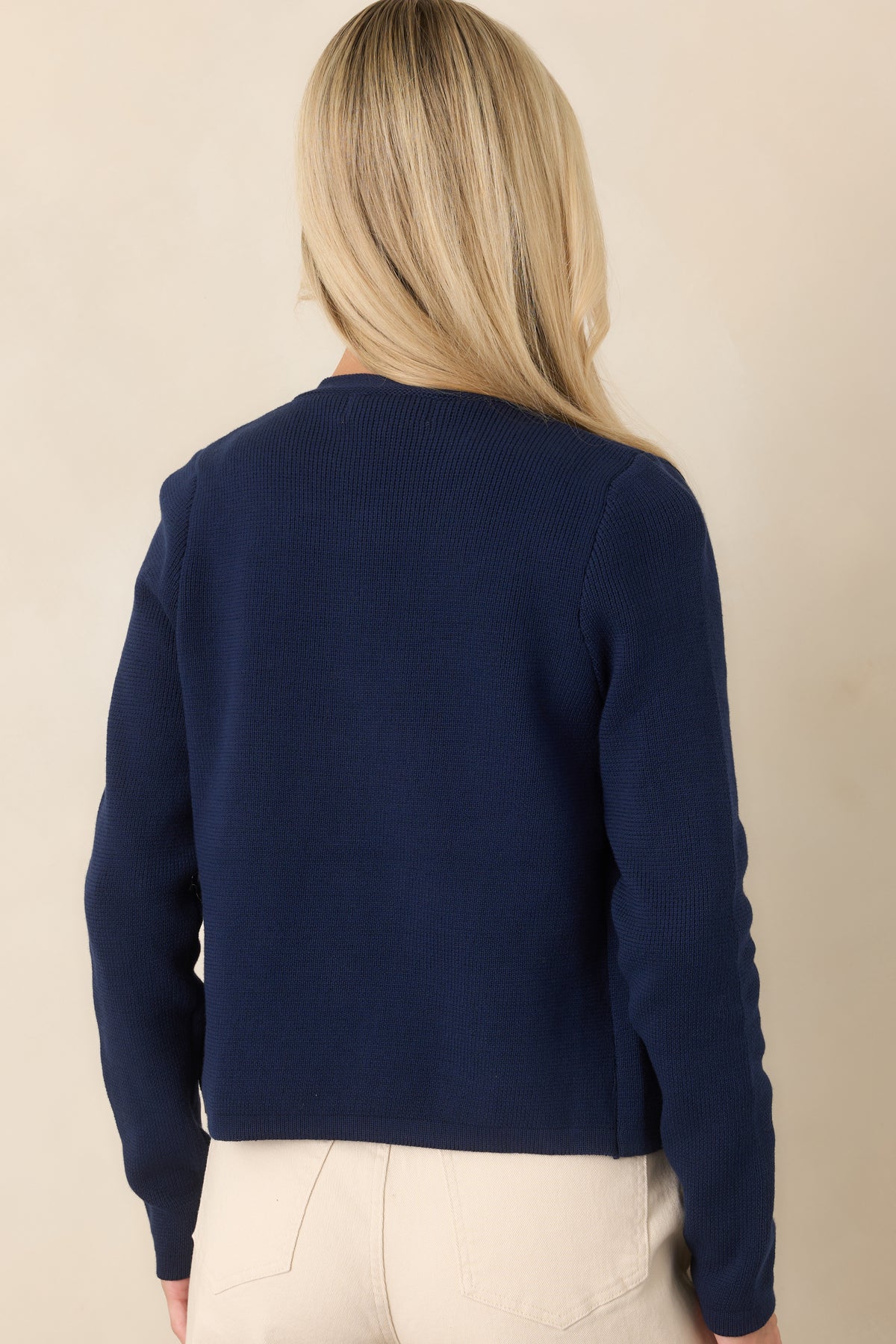 Rear view of the soft cotton knit cardigan showing its classic crew neckline, long sleeves, and clean relaxed silhouette.