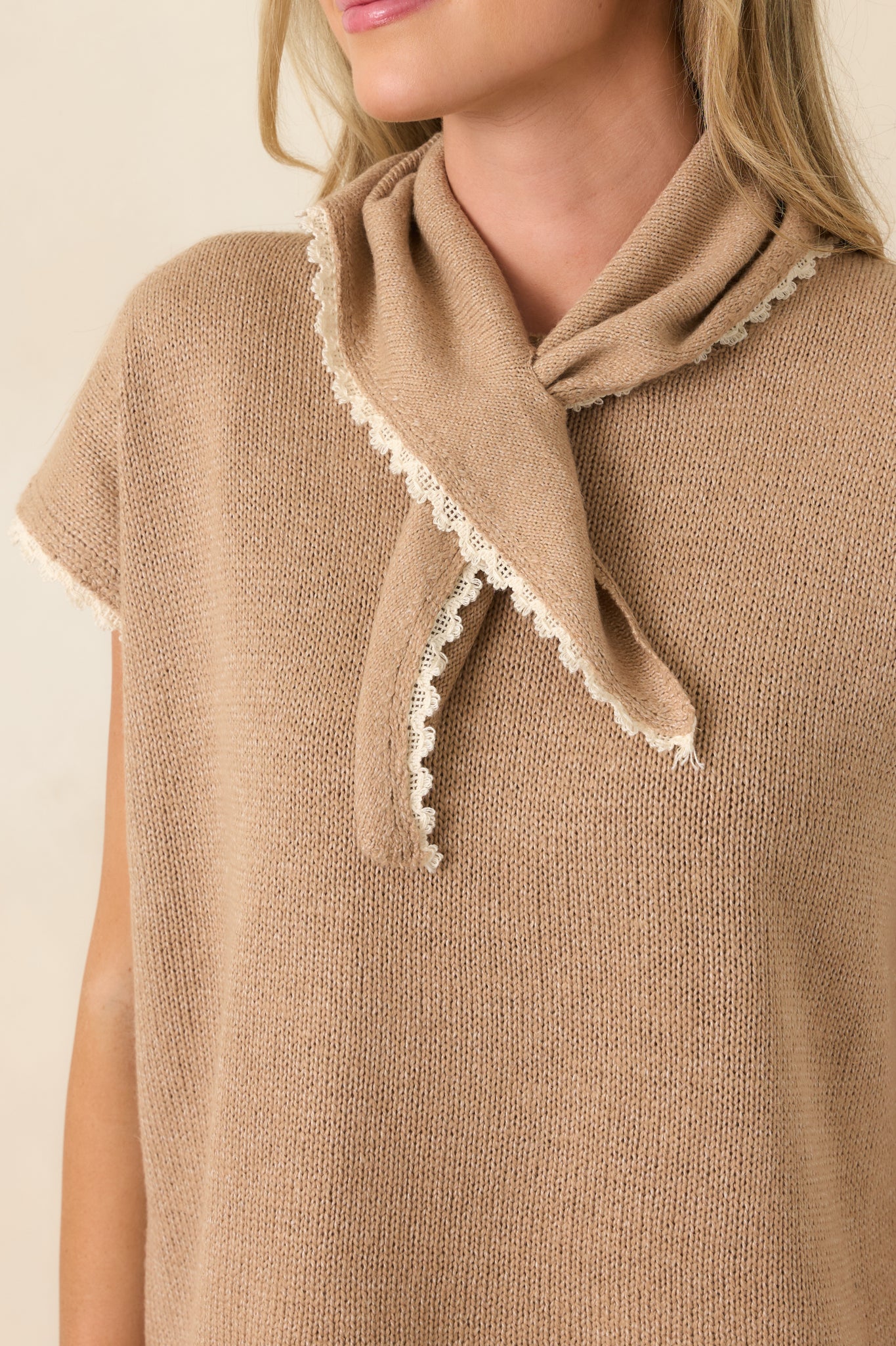 Close-up of the cotton knit top highlighting the built-in scarf neckline, ivory contrast trim, and textured knit construction.