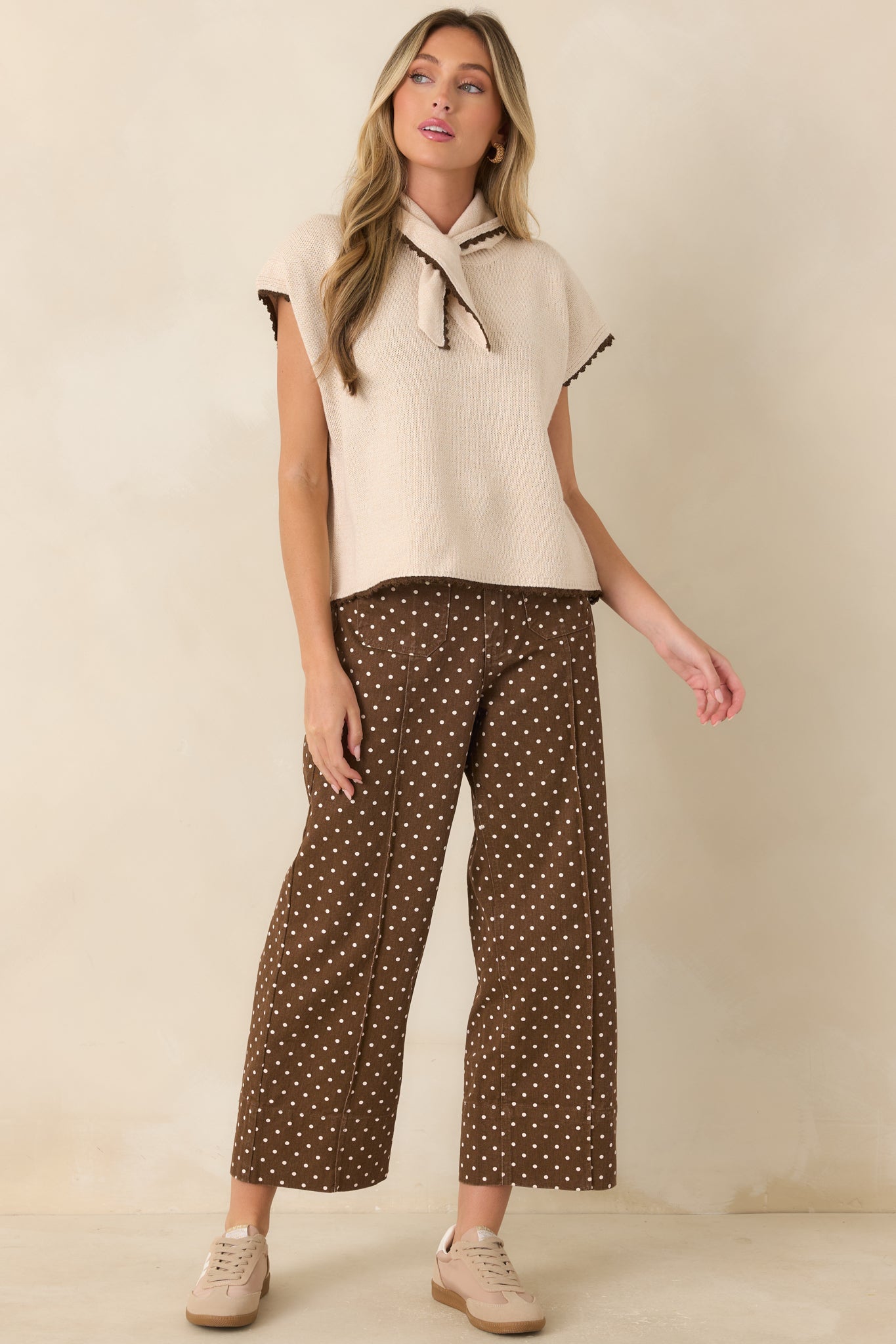 Cotton knit top featuring an attached scarf neckline, contrast trim along the sleeves and hem, and a relaxed silhouette.