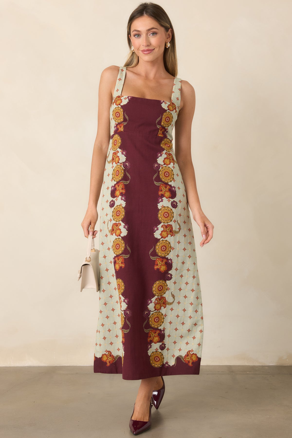 Cotton-linen blend dress with wide shoulder straps, a structured waist, and gently flared skirt.