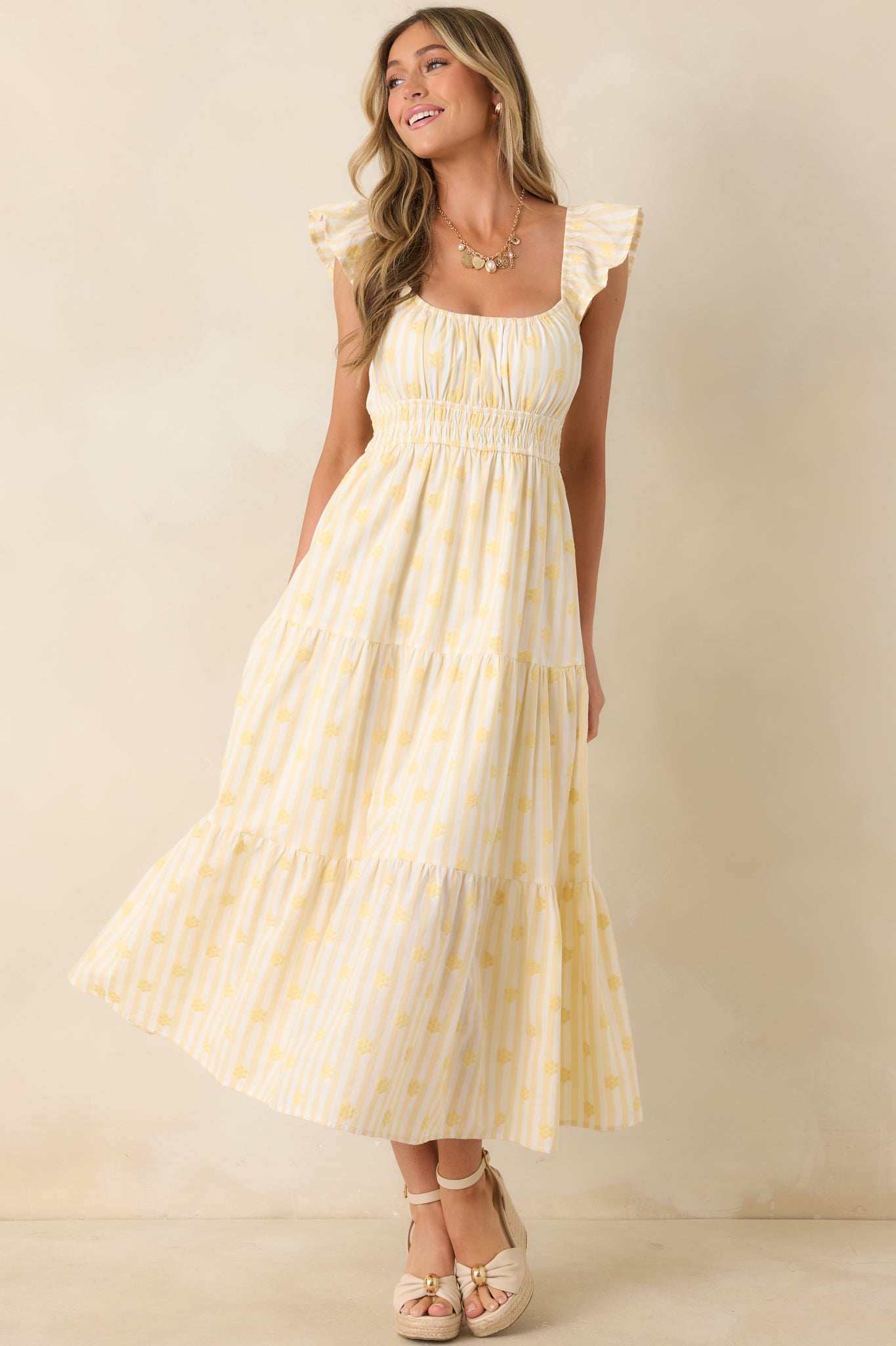 Cotton maxi dress with yellow stripes, flutter sleeves, and a softly flowing silhouette designed for effortless wear.