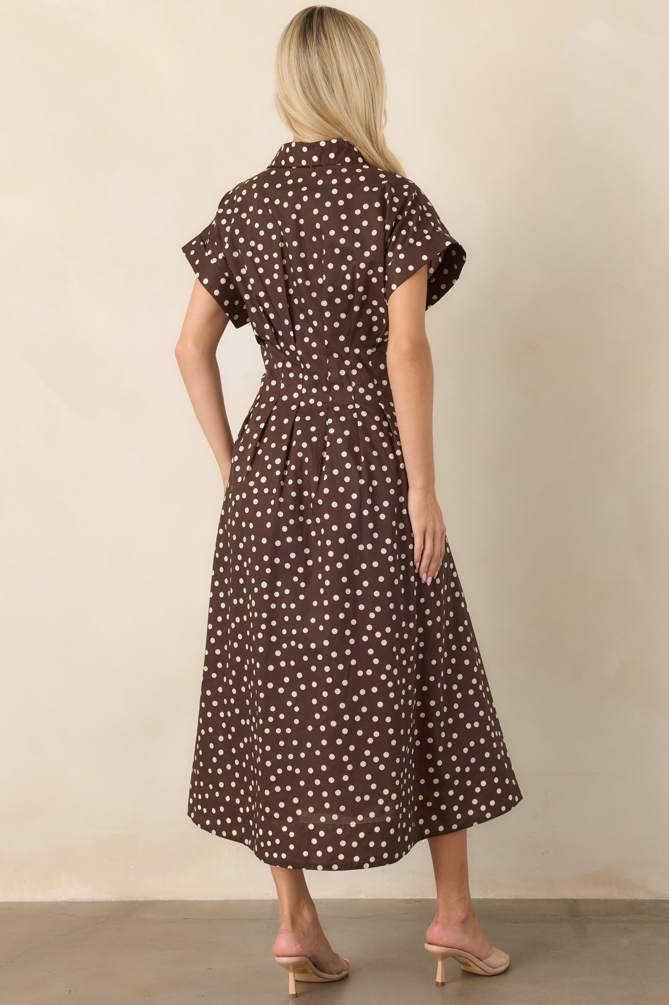 Rear view of the cotton midi dress showcasing the tailored waist seams, short sleeves, and full flowing skirt for a defined fit-and-flare silhouette.