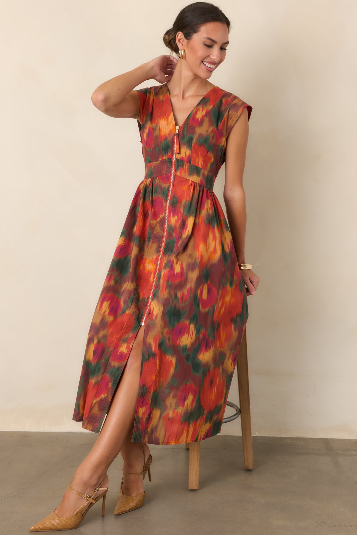 100% cotton midi dress with a V-neckline, structured cap sleeves, cinched waist, front gold-tone zipper, and full skirt.