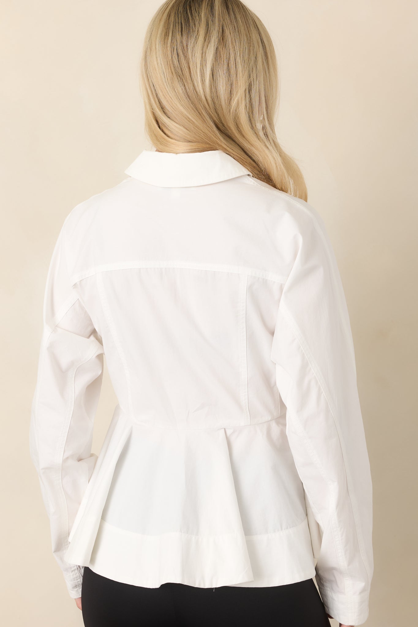 Rear view of the cotton peplum top showcasing the back yoke, pleated peplum, and structured waist.