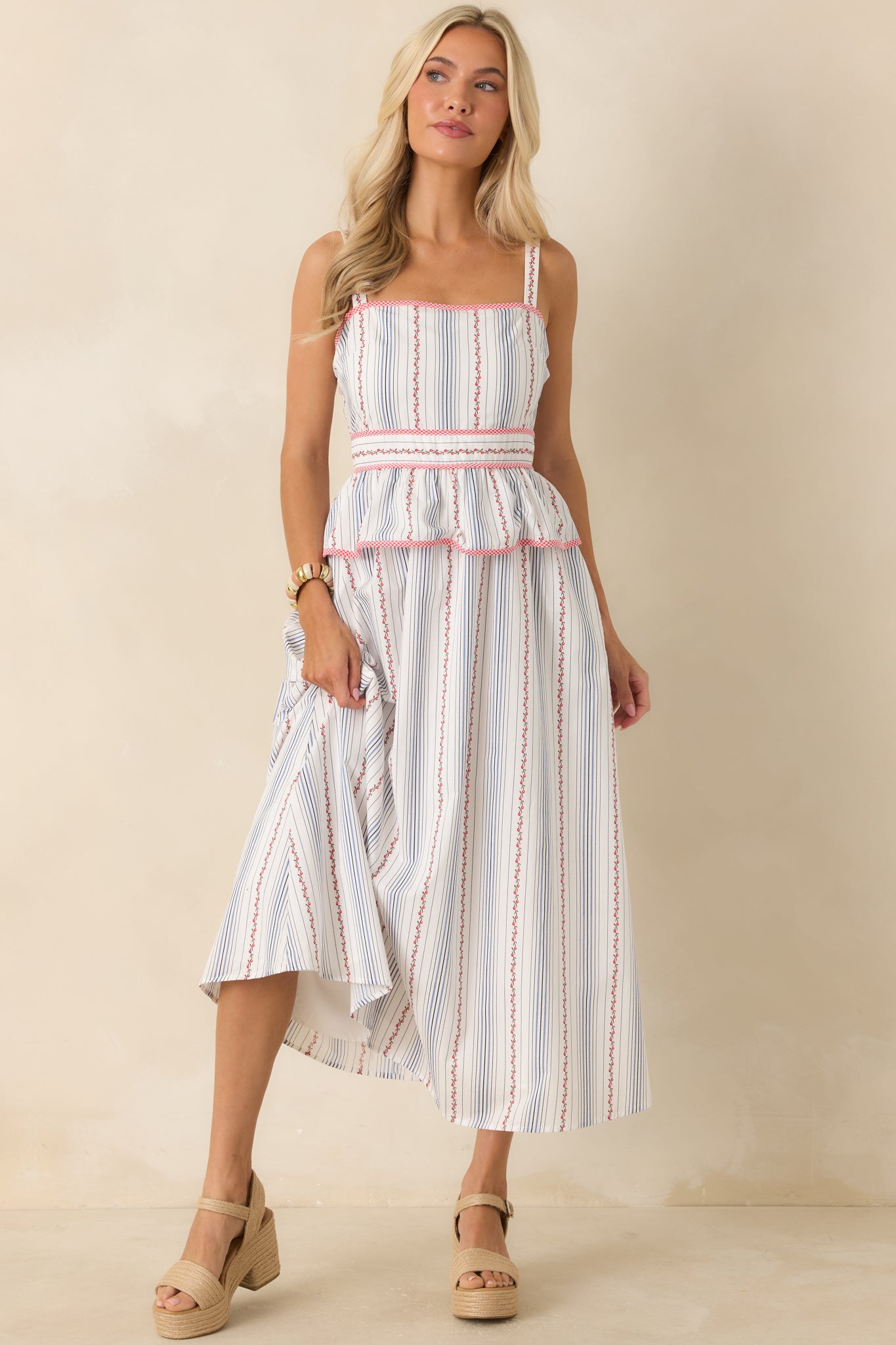 Cotton midi dress designed with a square neckline, adjustable straps, playful peplum detail, and a full skirt with side pockets.
