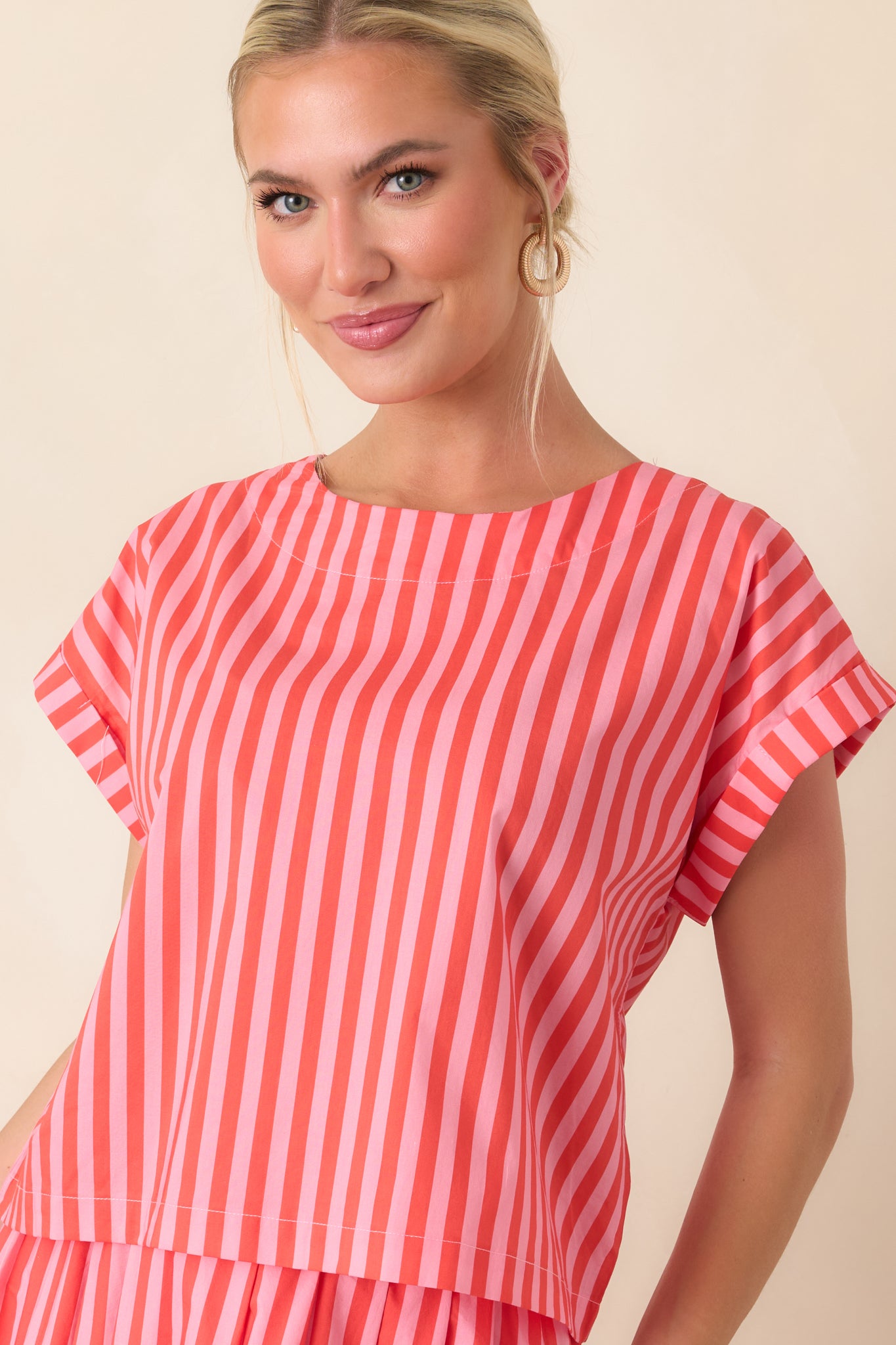 Front view of the cotton top highlighting vertical orange and pink stripes with a relaxed boxy shape and neatly finished hem.