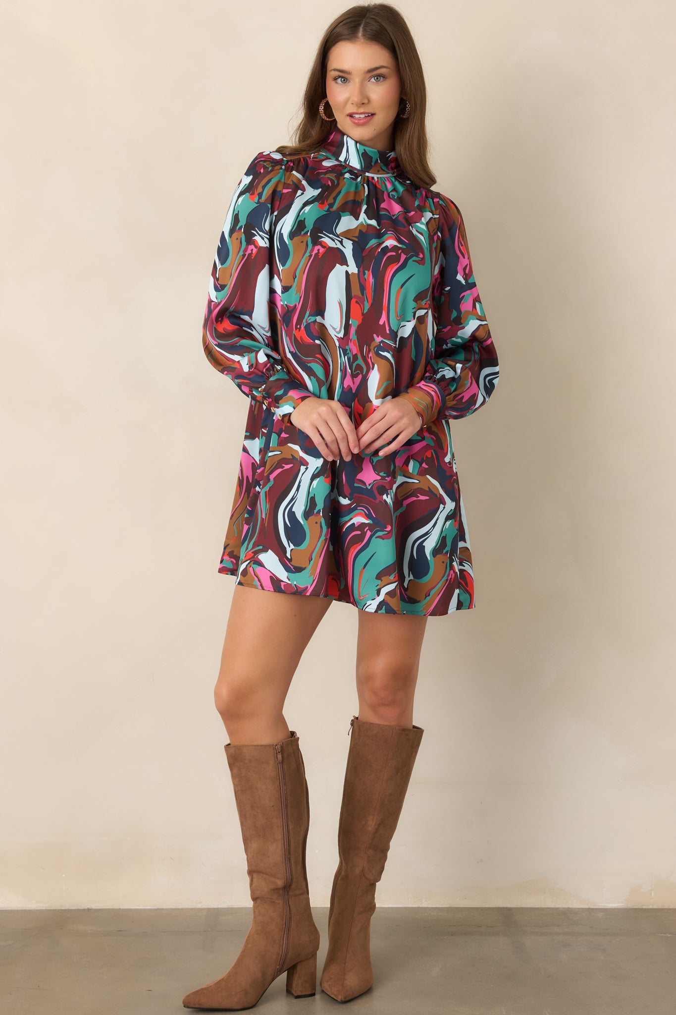 Statement-making mini dress with a softly draped cowl neckline, tied neck detail, gathered shoulders, and long sleeves finished with buttoned cuffs.