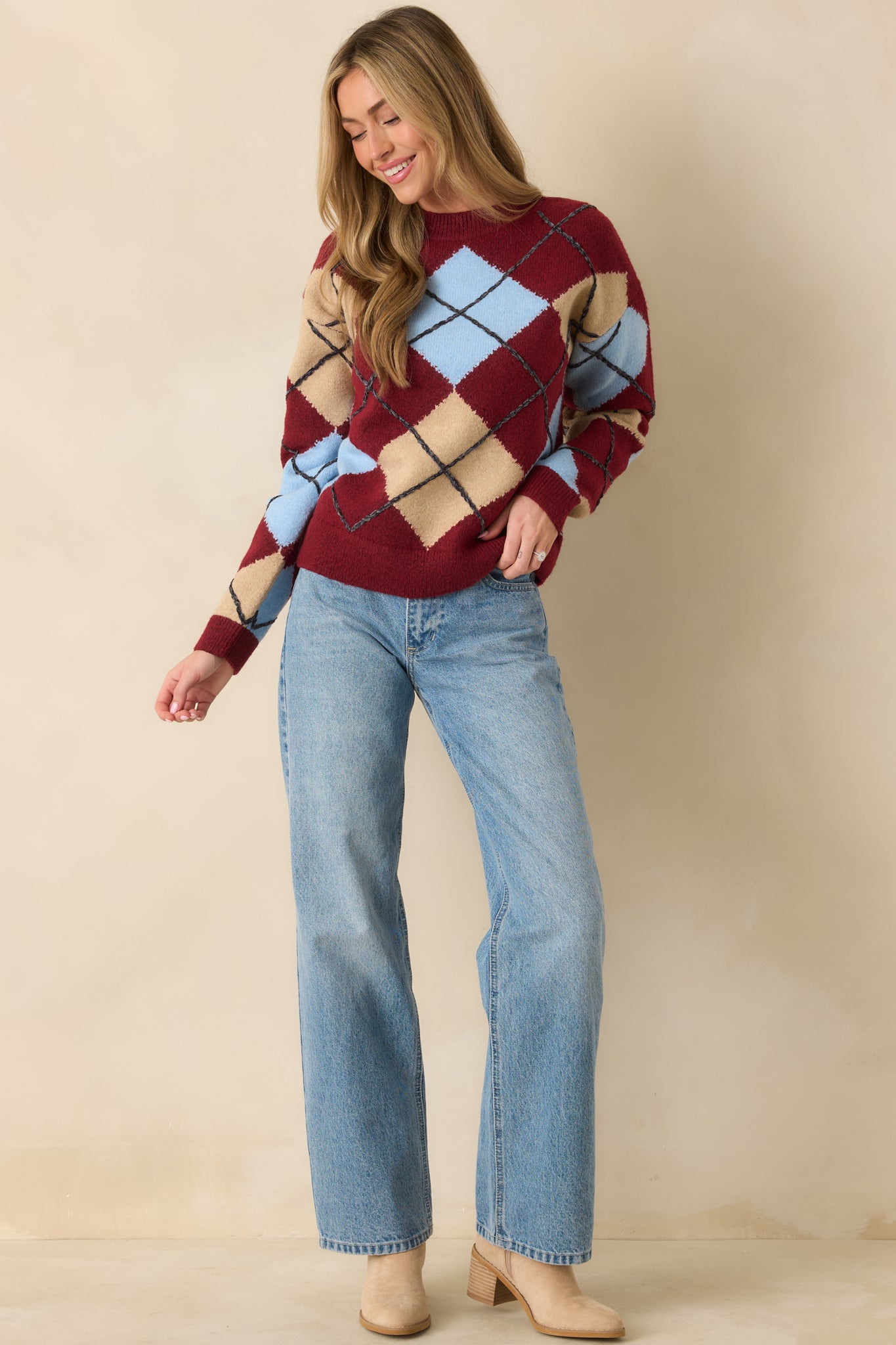 Cozy knit top in burgundy with eye-catching argyle detailing on sleeves.