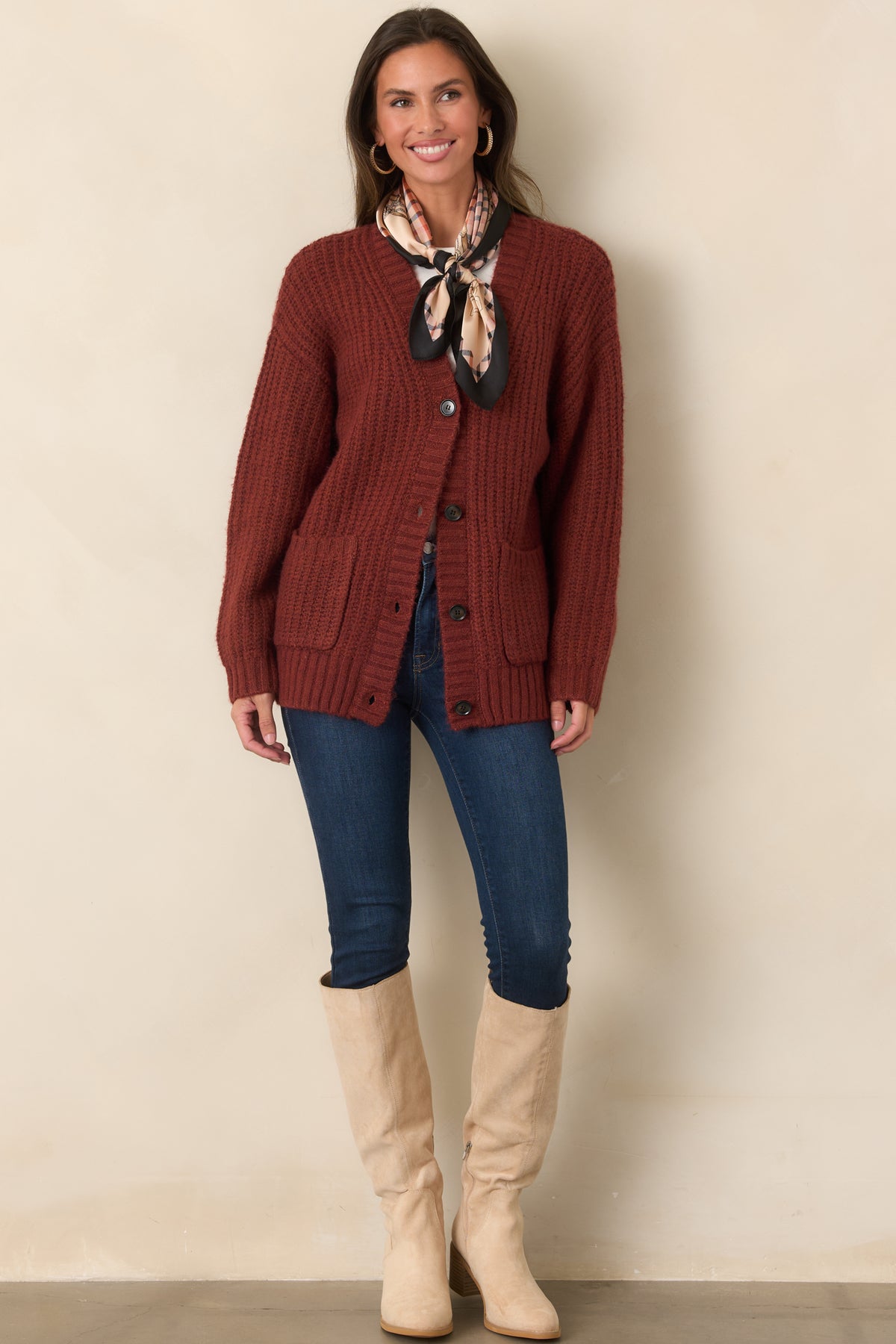 Cozy knit cardigan with a relaxed oversized shape, long sleeves, wide ribbed trim, and dark front buttons.