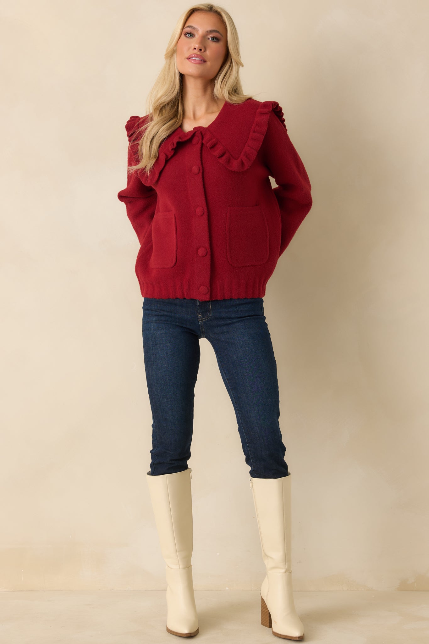 Cozy knit cardigan in red with statement ruffle collar and practical front pockets.