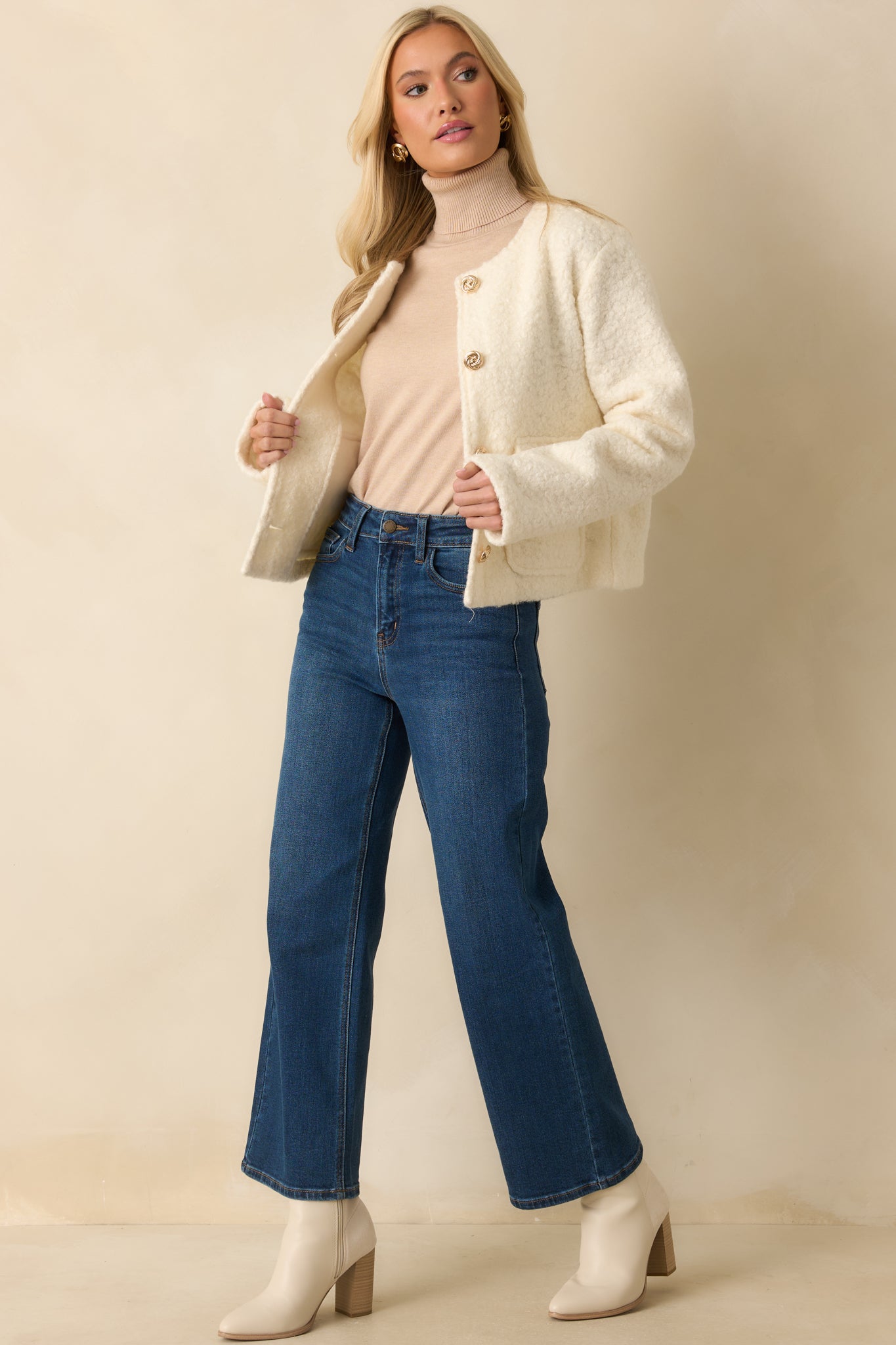 Elegant cream bouclé jacket with a classic round neckline, structured fit, and decorative gold buttons.