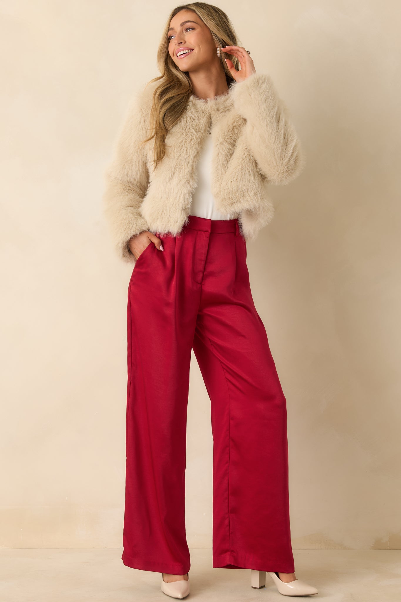 Cream-colored faux fur jacket styled closed, showing its cozy, long-length design and sleeve length.