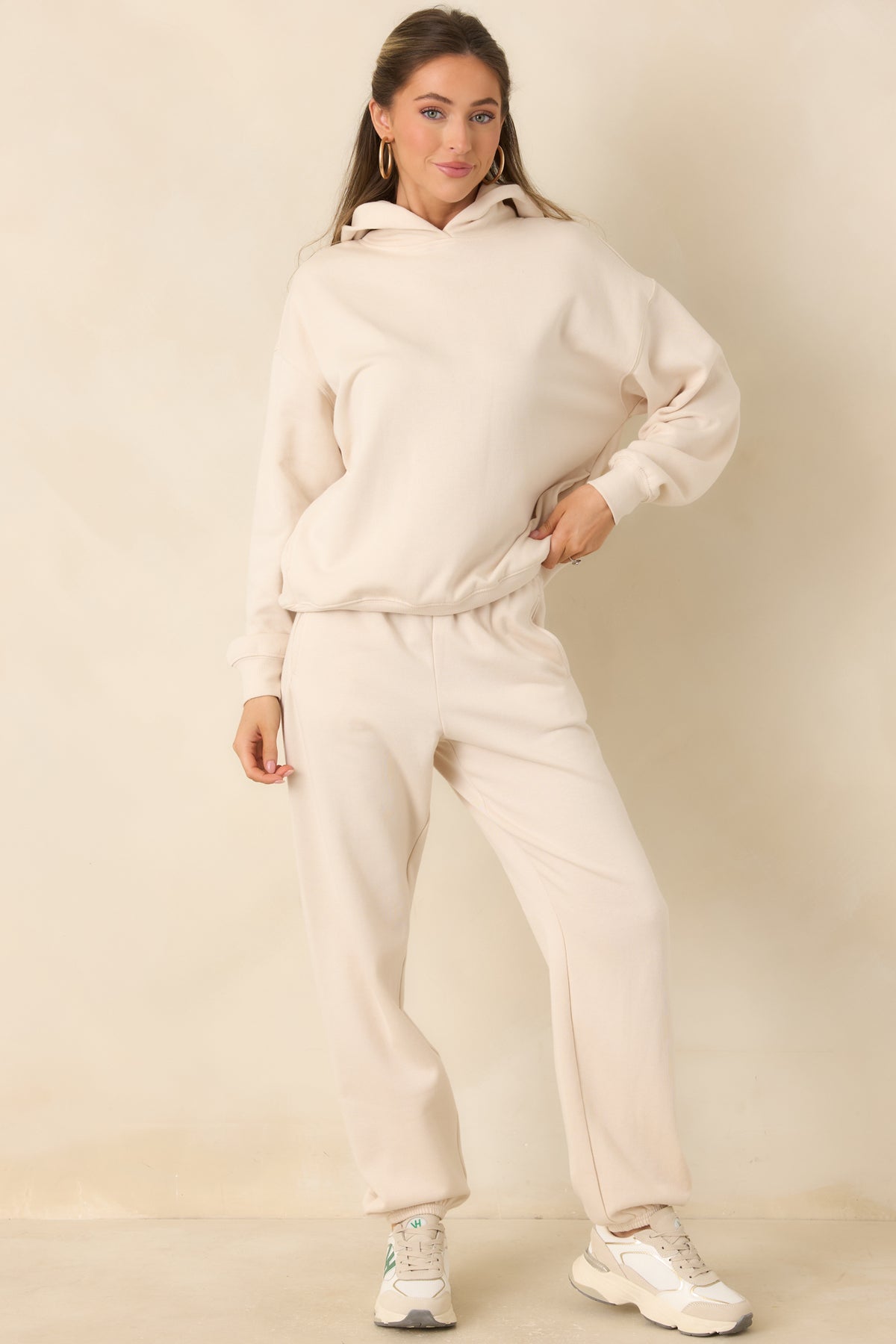 Cream hooded sweatshirt with dropped shoulders and ribbed sleeve cuffs.