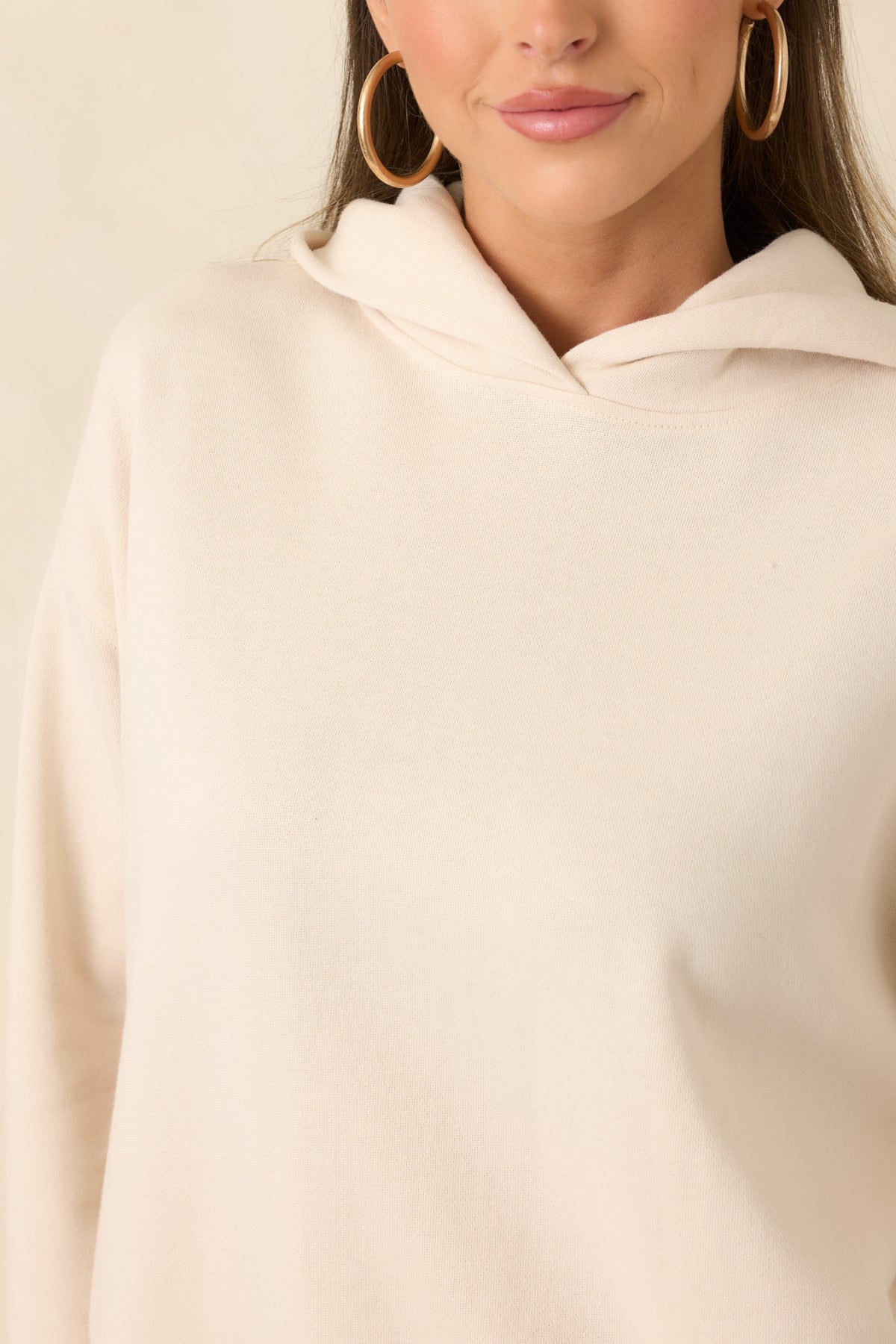 Close-up of the soft cotton-blend fleece and ribbed trim on the cream hoodie.