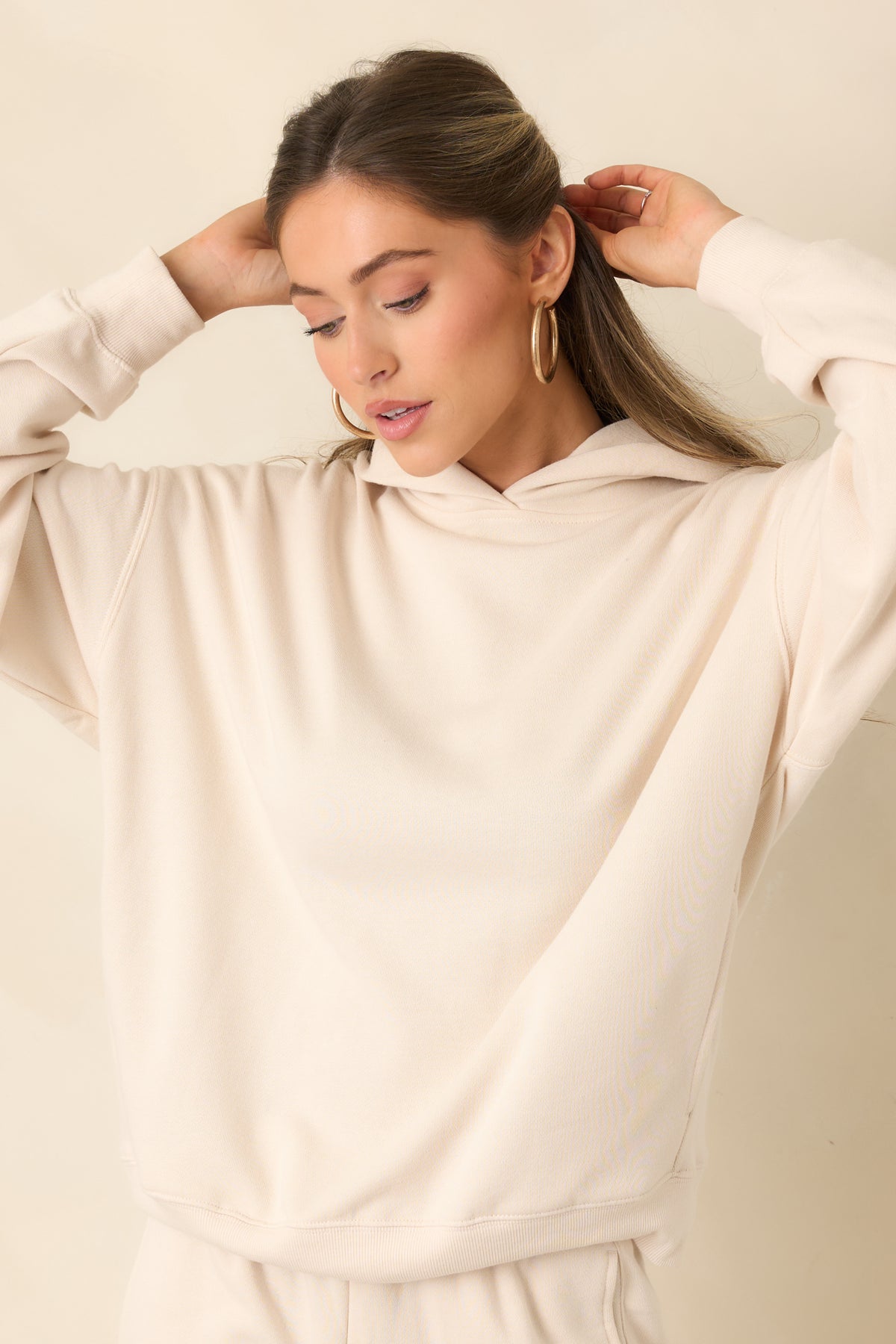 Wide ribbed hem adding structure to the relaxed cream sweatshirt.