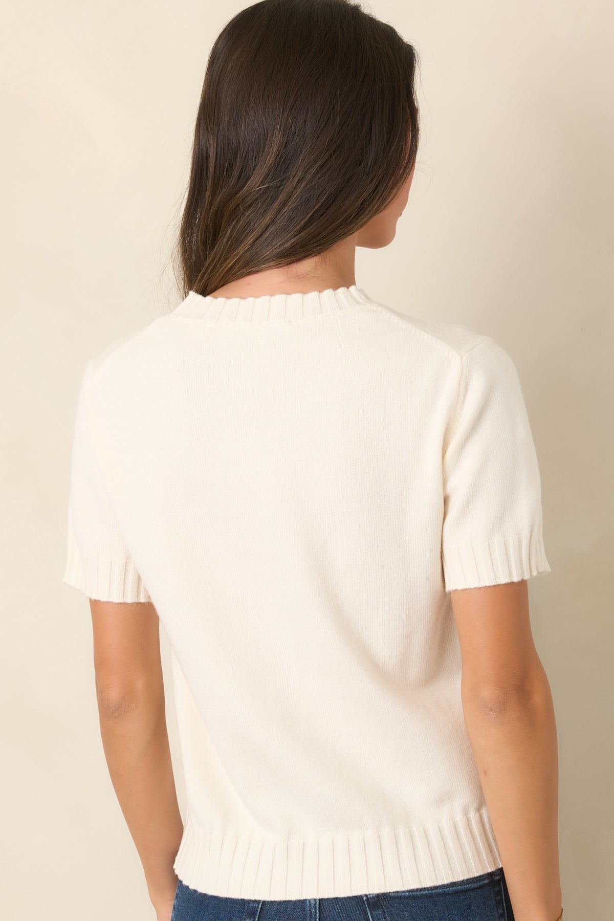Rear of the creamy ivory wool-blend top showcasing the relaxed fit, short sleeves, and ribbed hem.