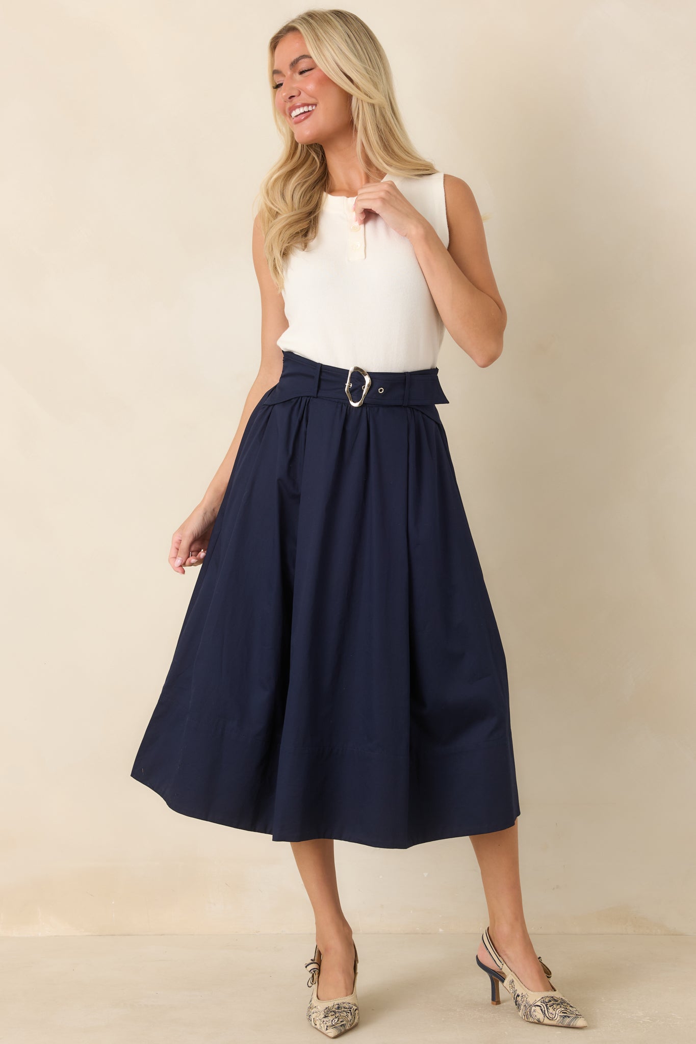 Crisp cotton skirt with a softly structured silhouette, side pockets, and a modern silver buckle accent.