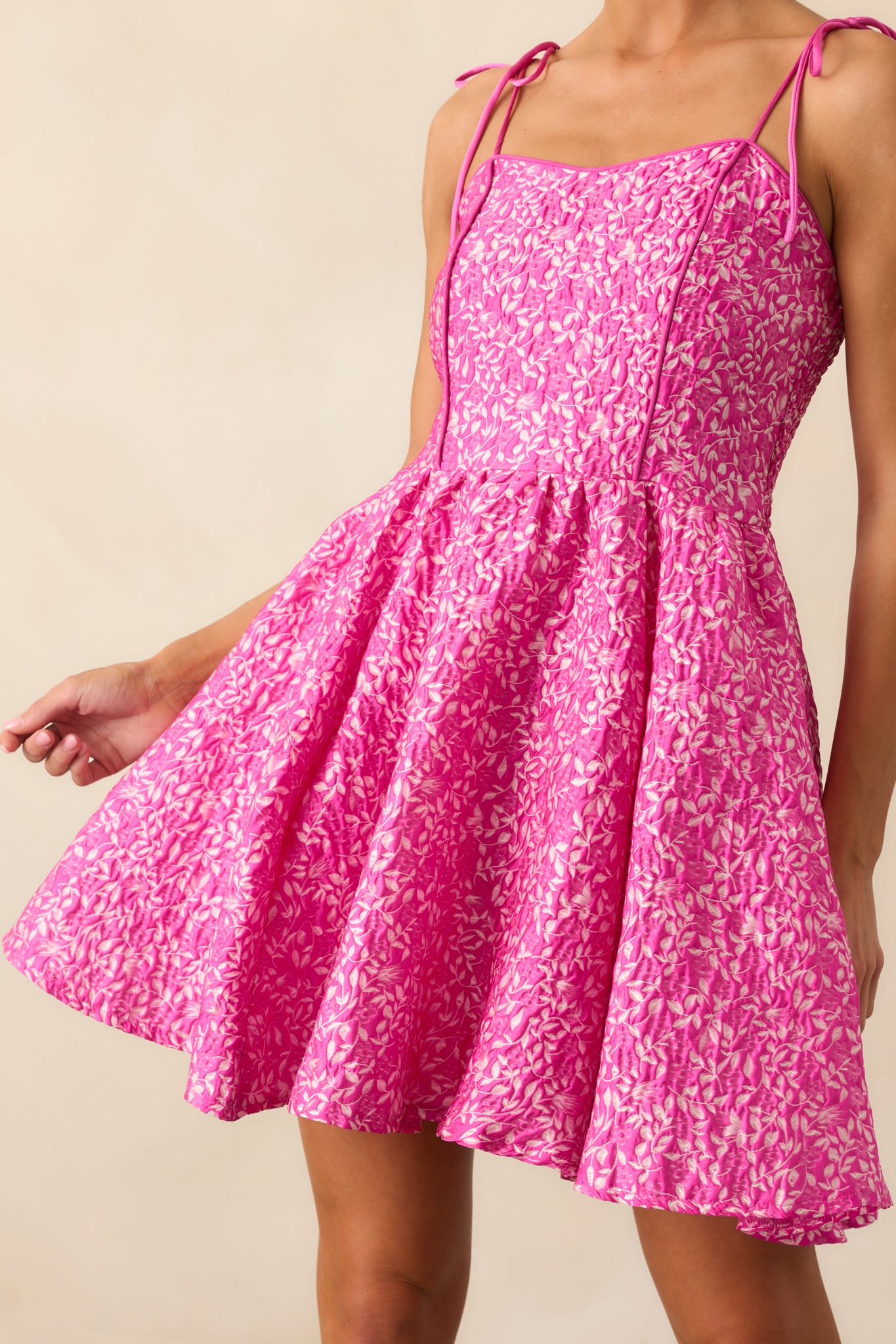 Close crop of the dress's bodice, emphasizing the texture and floral pattern.