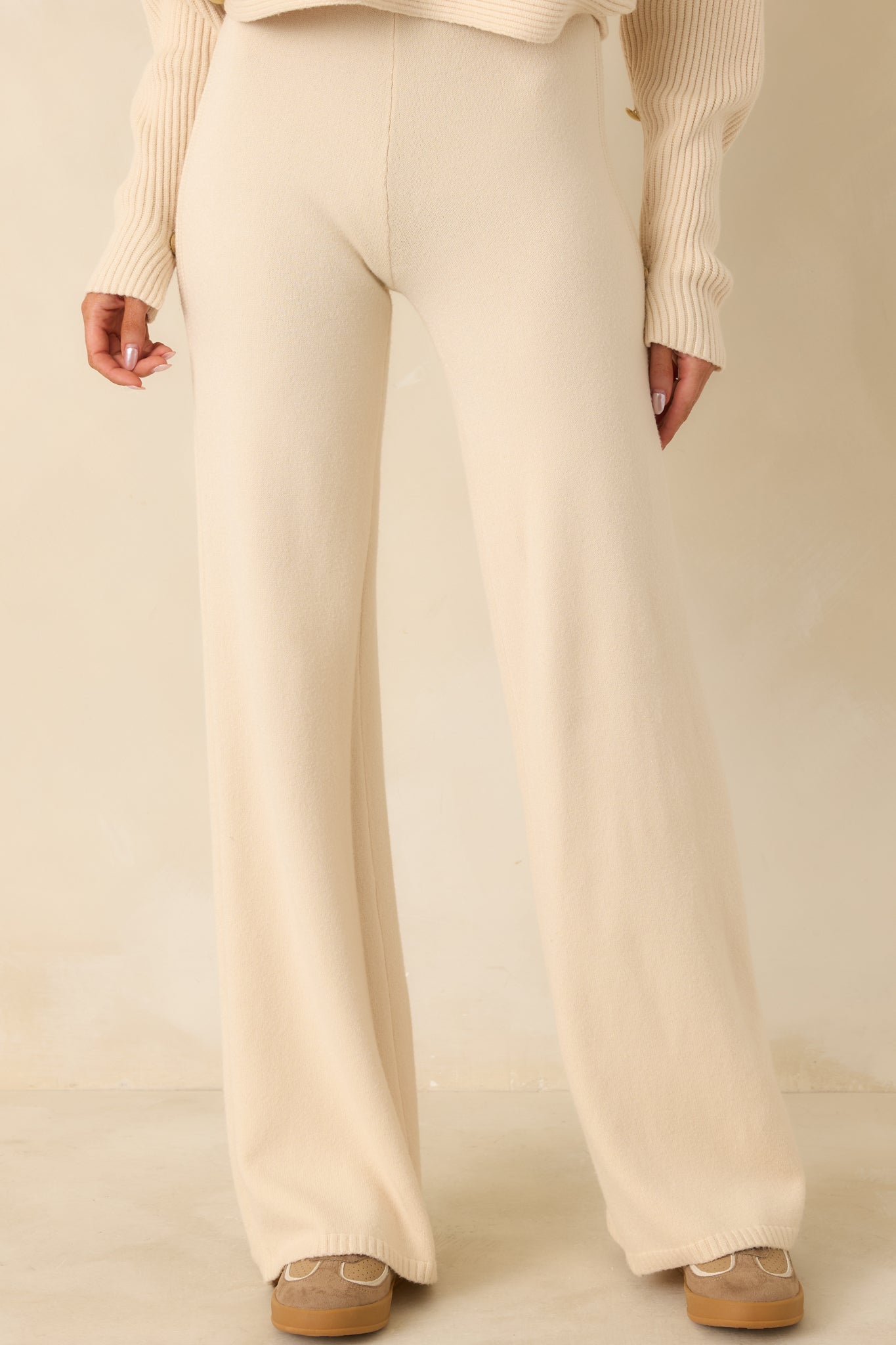 Cropped view showing high-rise waistband and wide-leg shape of knit pants.