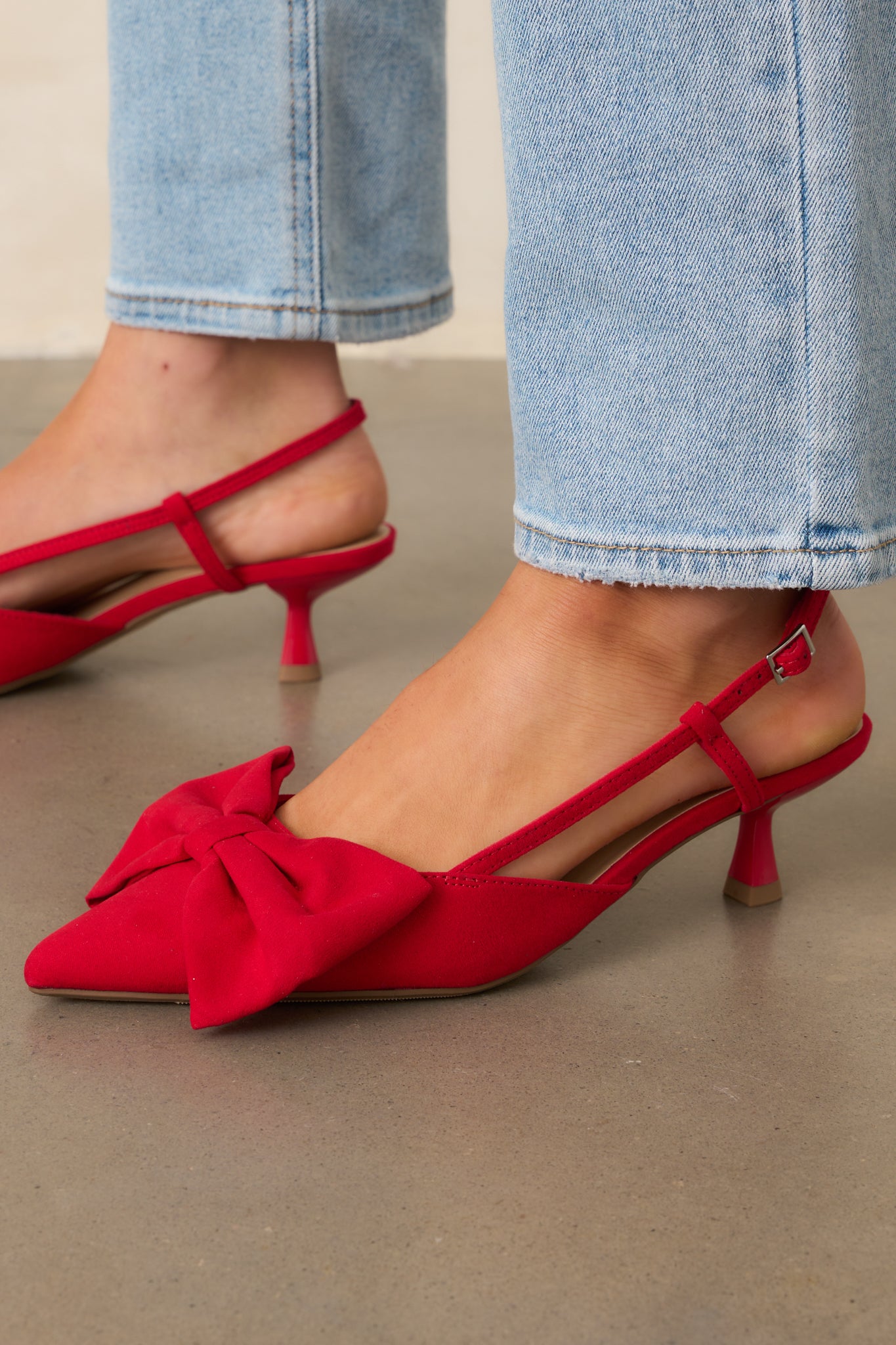 Cropped angle of the red heels emphasizing the pointed toe and overall silhouette.