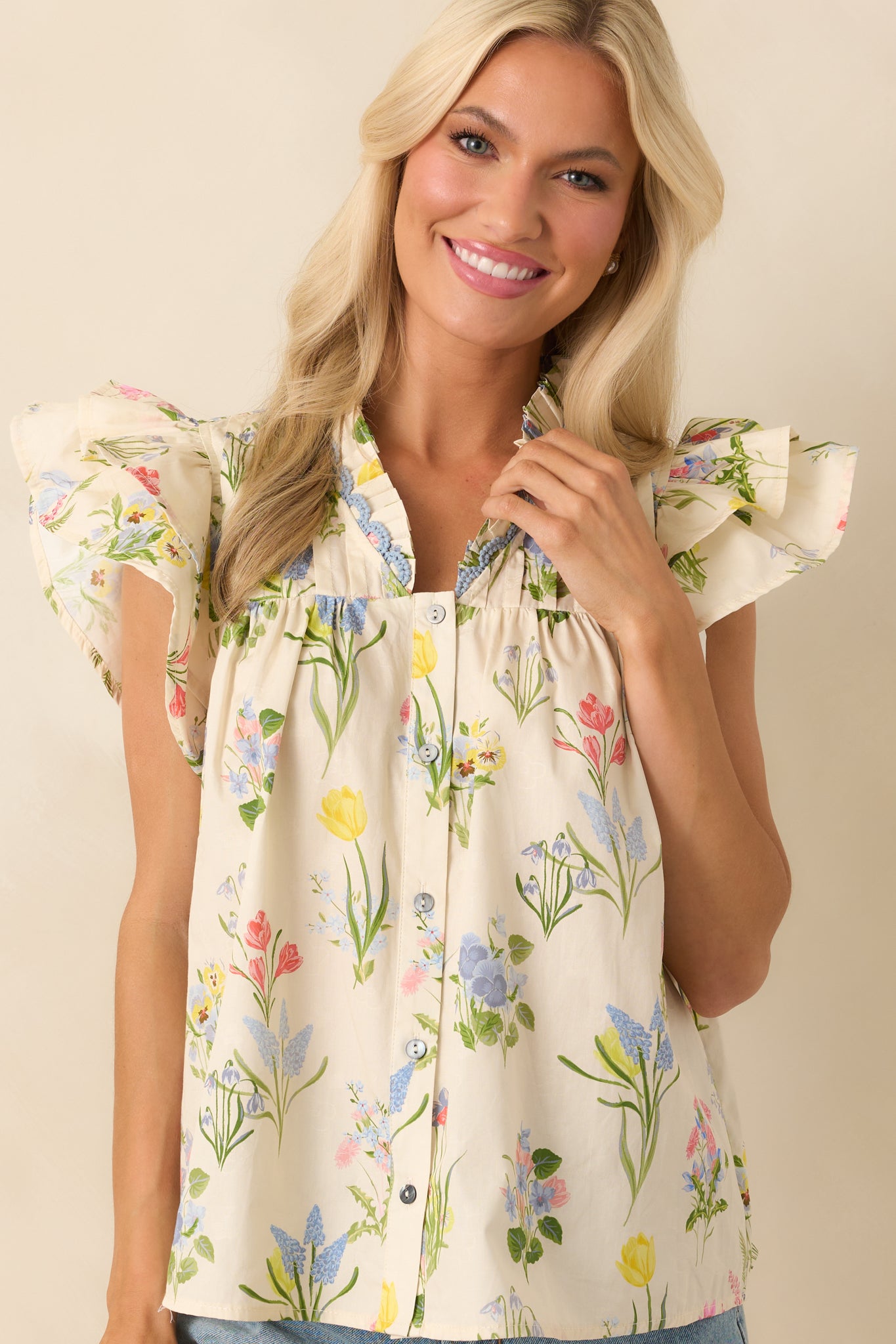 Cropped front angle featuring the ruffle v-neckline and top portion of the functional button front.