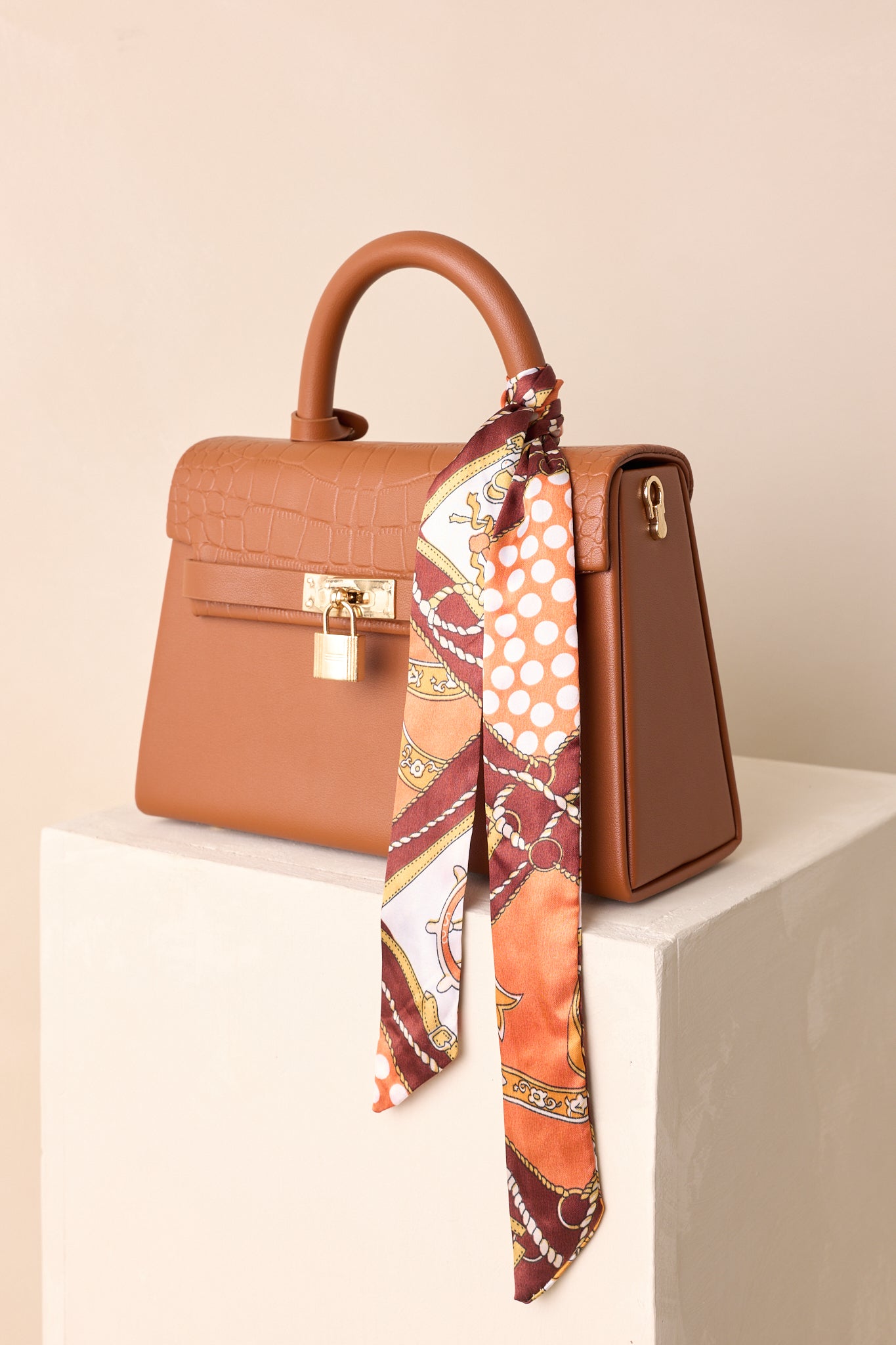 A cropped angled view focusing on the padlock hardware and scarf detail on the handle.