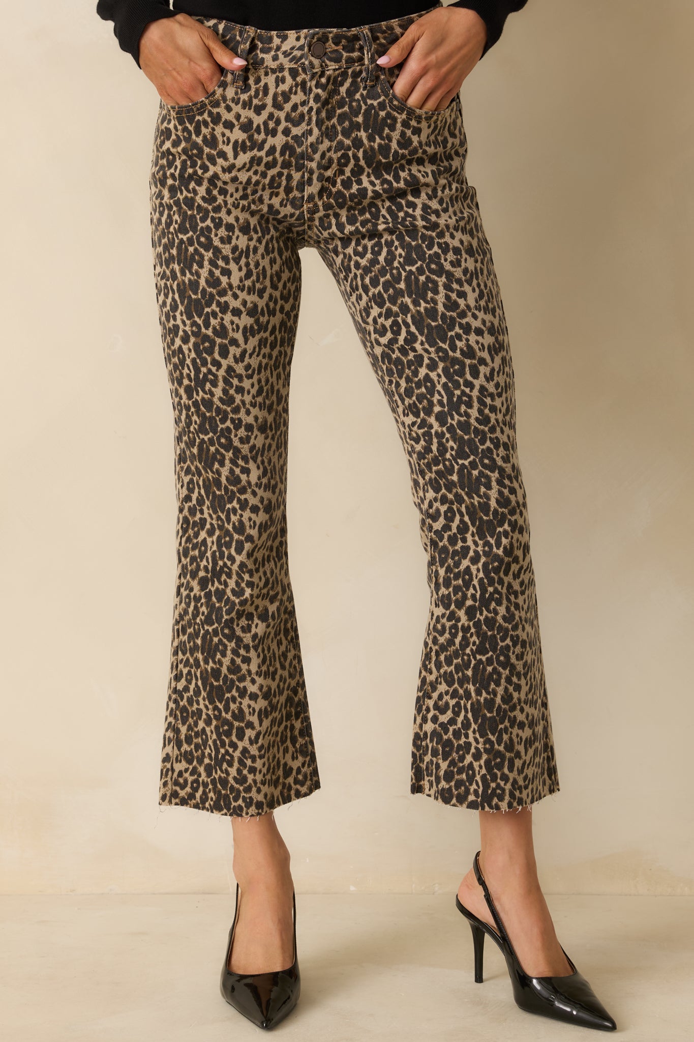 Cropped view emphasizing the belt loops and fabric pattern of the leopard print flare pants.