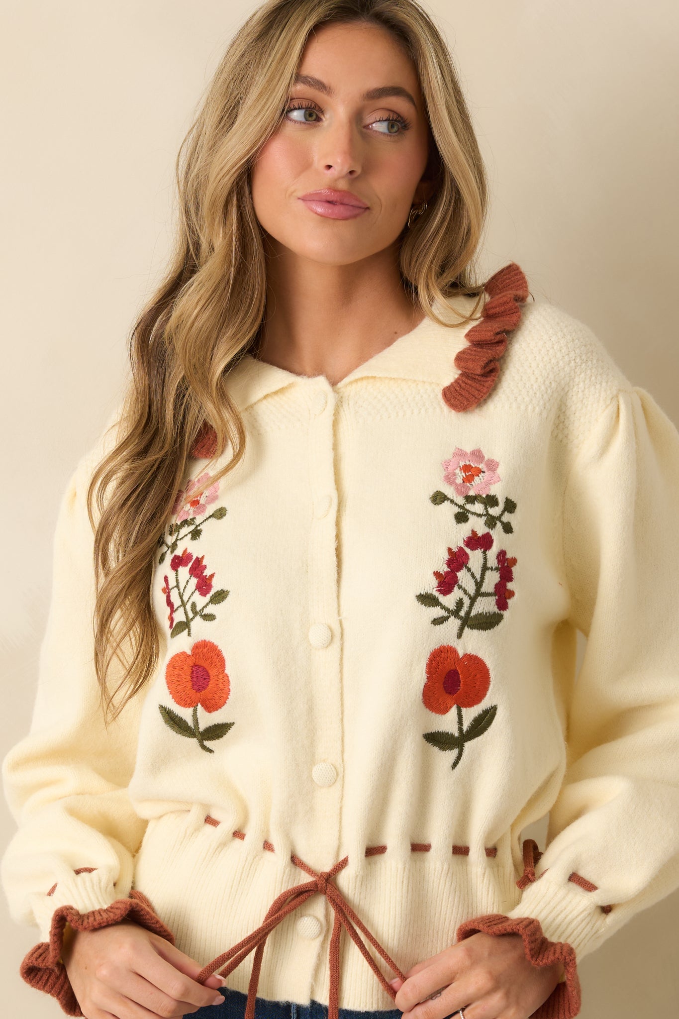Cropped shot of cardigan front focusing on floral embroidery and vintage-inspired styling.