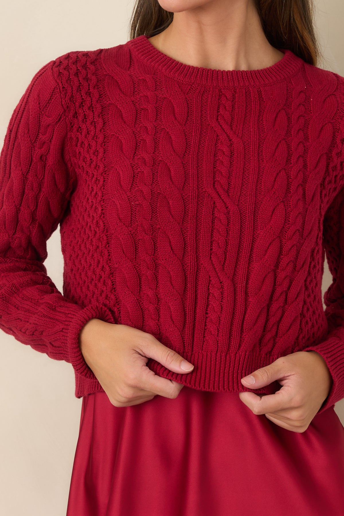 Close-up of the cropped cotton sweater highlighting its intricate mixed cable-knit texture.