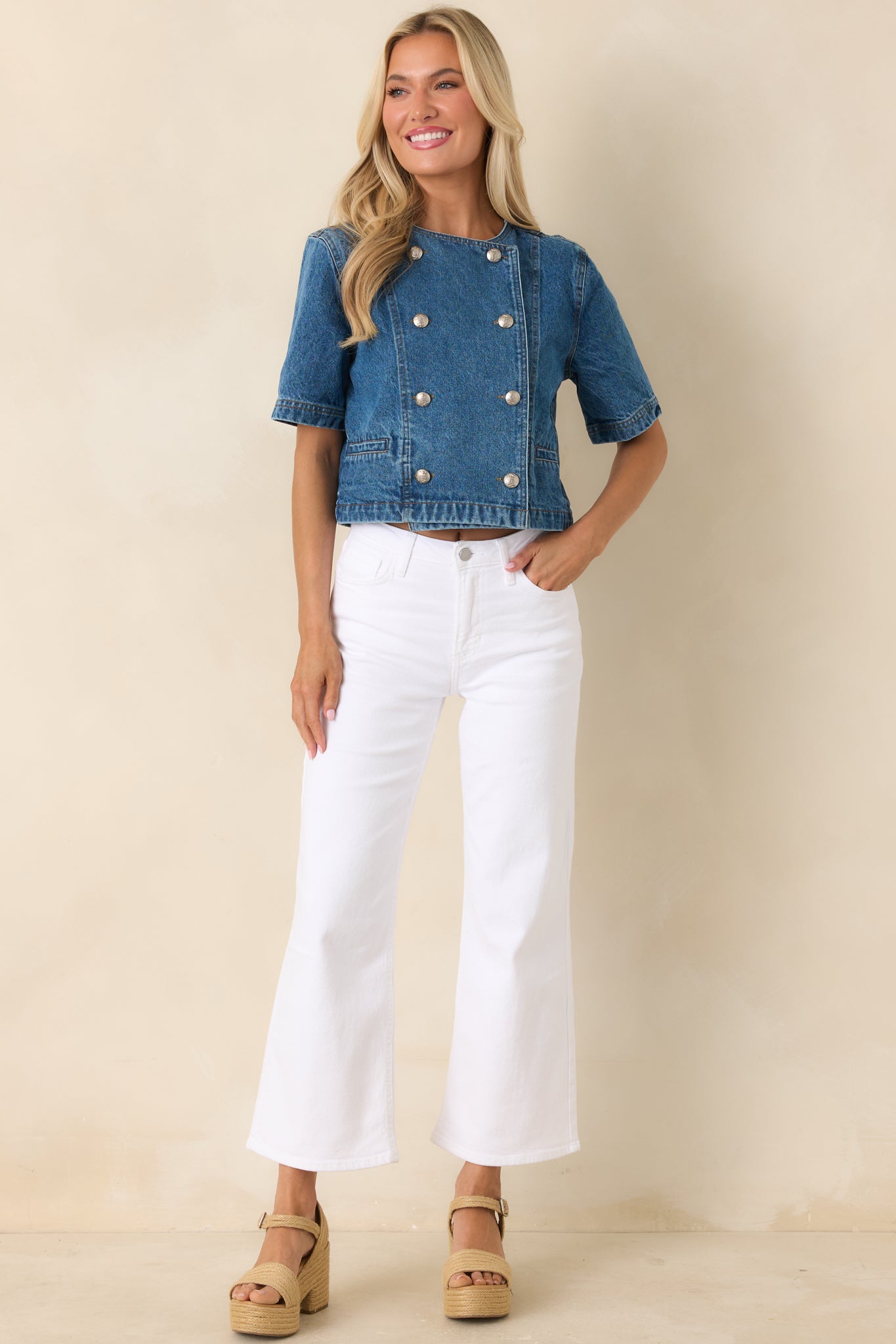 Cropped denim top in a medium wash featuring a structured fit, short sleeves, and decorative gold button detailing