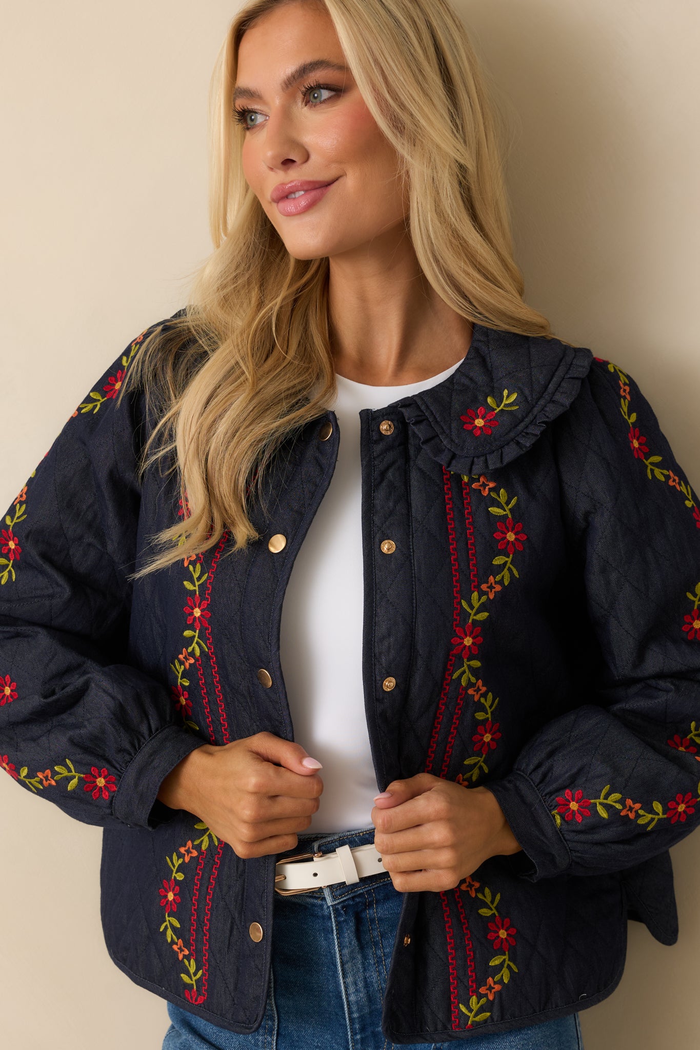 Cropped detail showcasing the diamond-quilt texture and embroidered floral pattern.