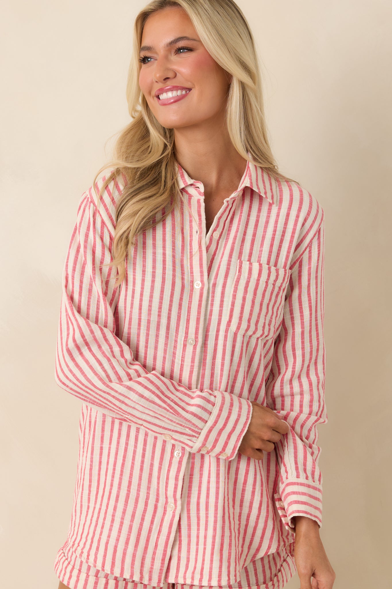 Close cropped detail of the button-front closure and collared neckline on the striped cotton shirt