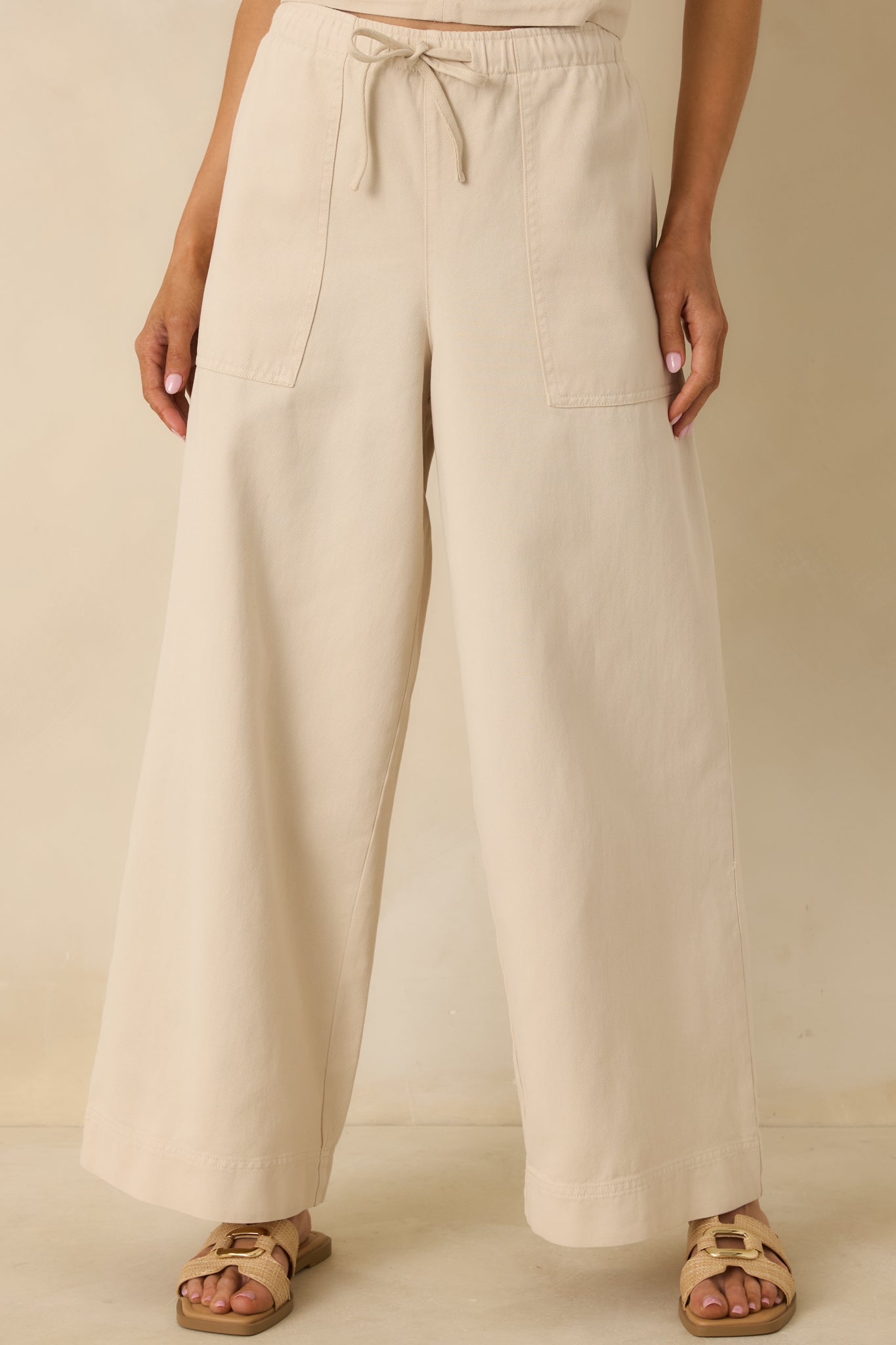 Cropped detail showing the functional front patch pockets and smooth, lightweight fabric.