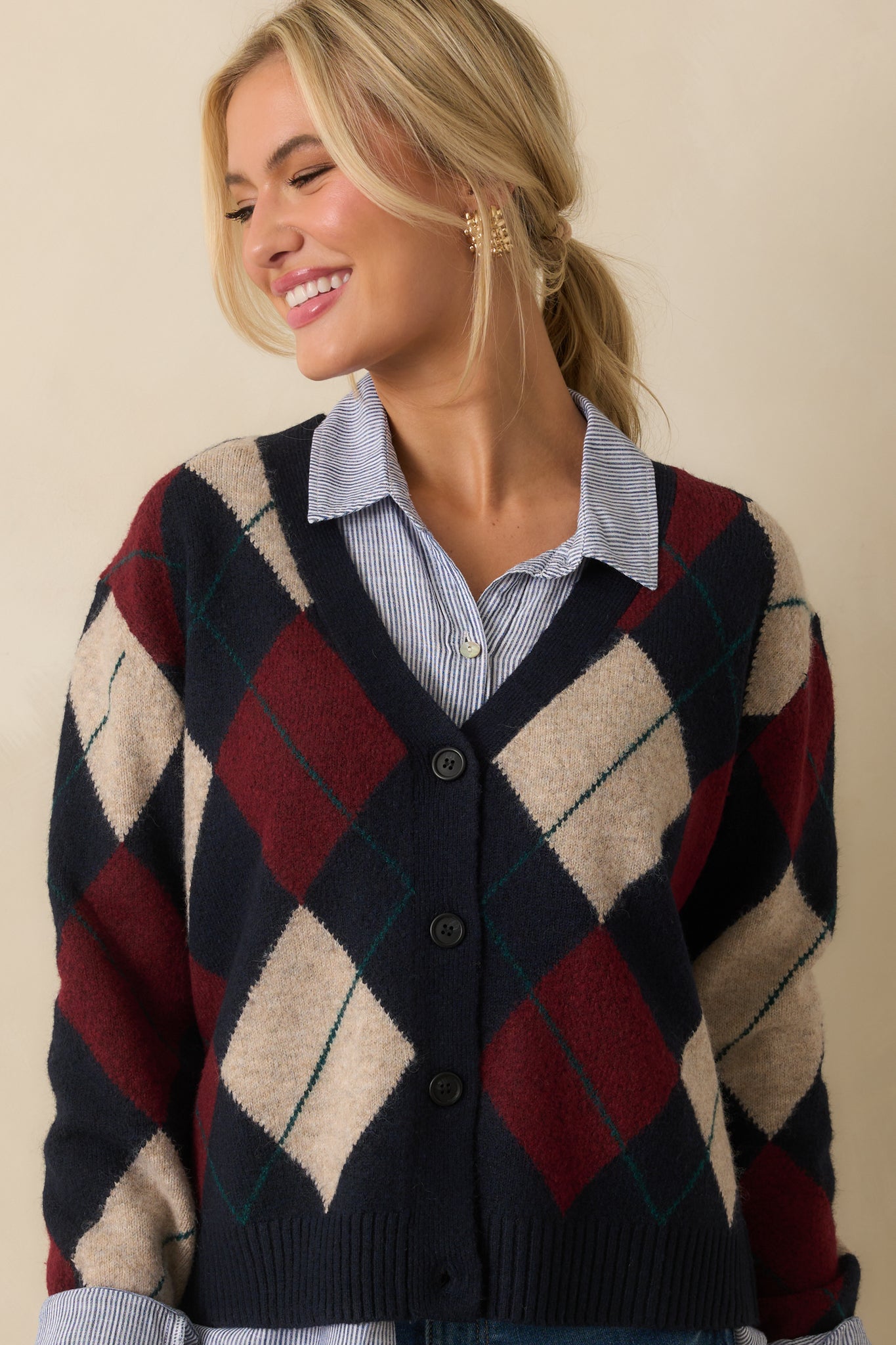 Cropped focus on the burgundy and ivory argyle pattern against navy fabric.