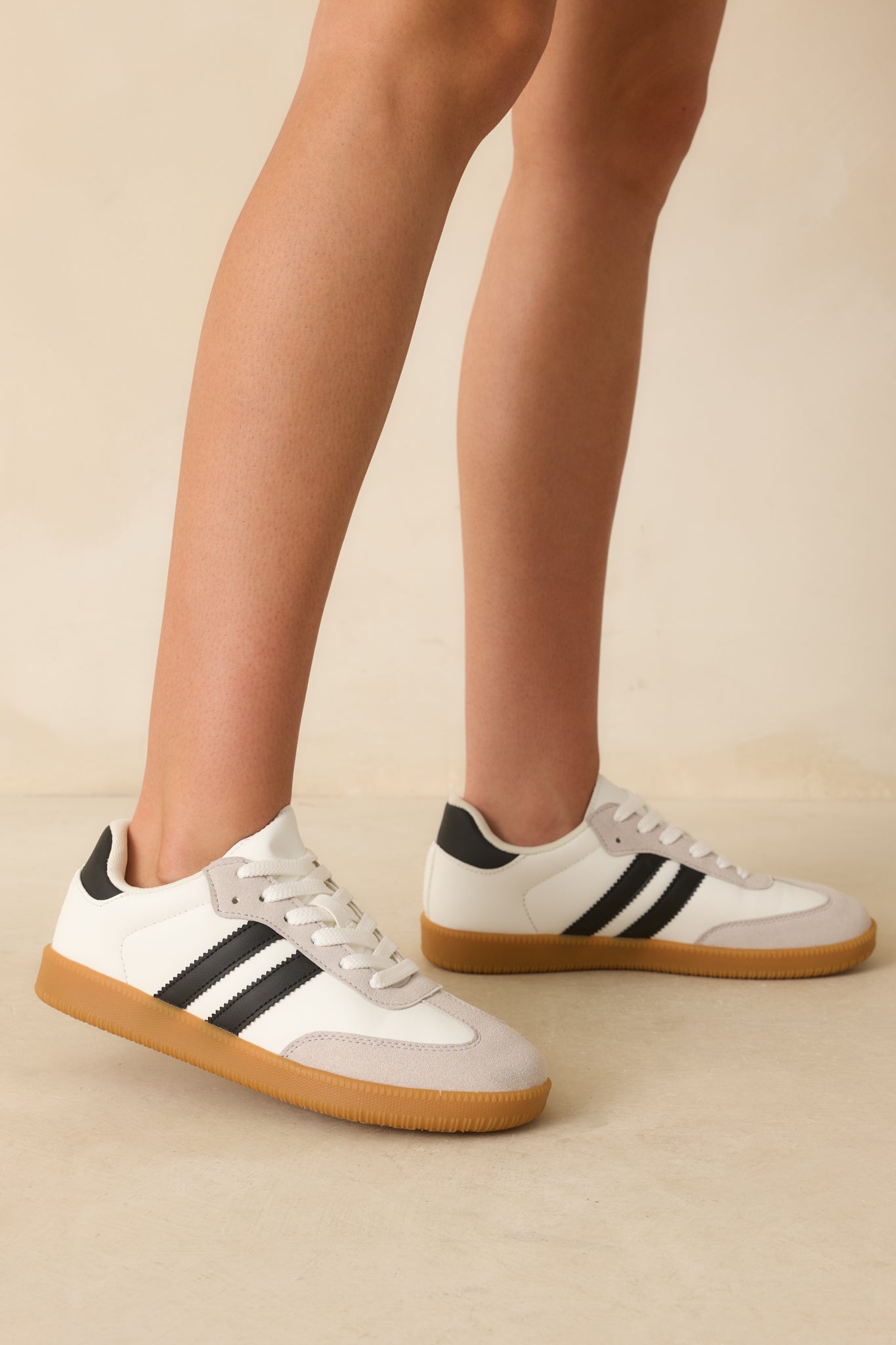 Cropped view focusing on the side stripe detail and the mix of faux leather and suede textures on the sneaker’s upper.