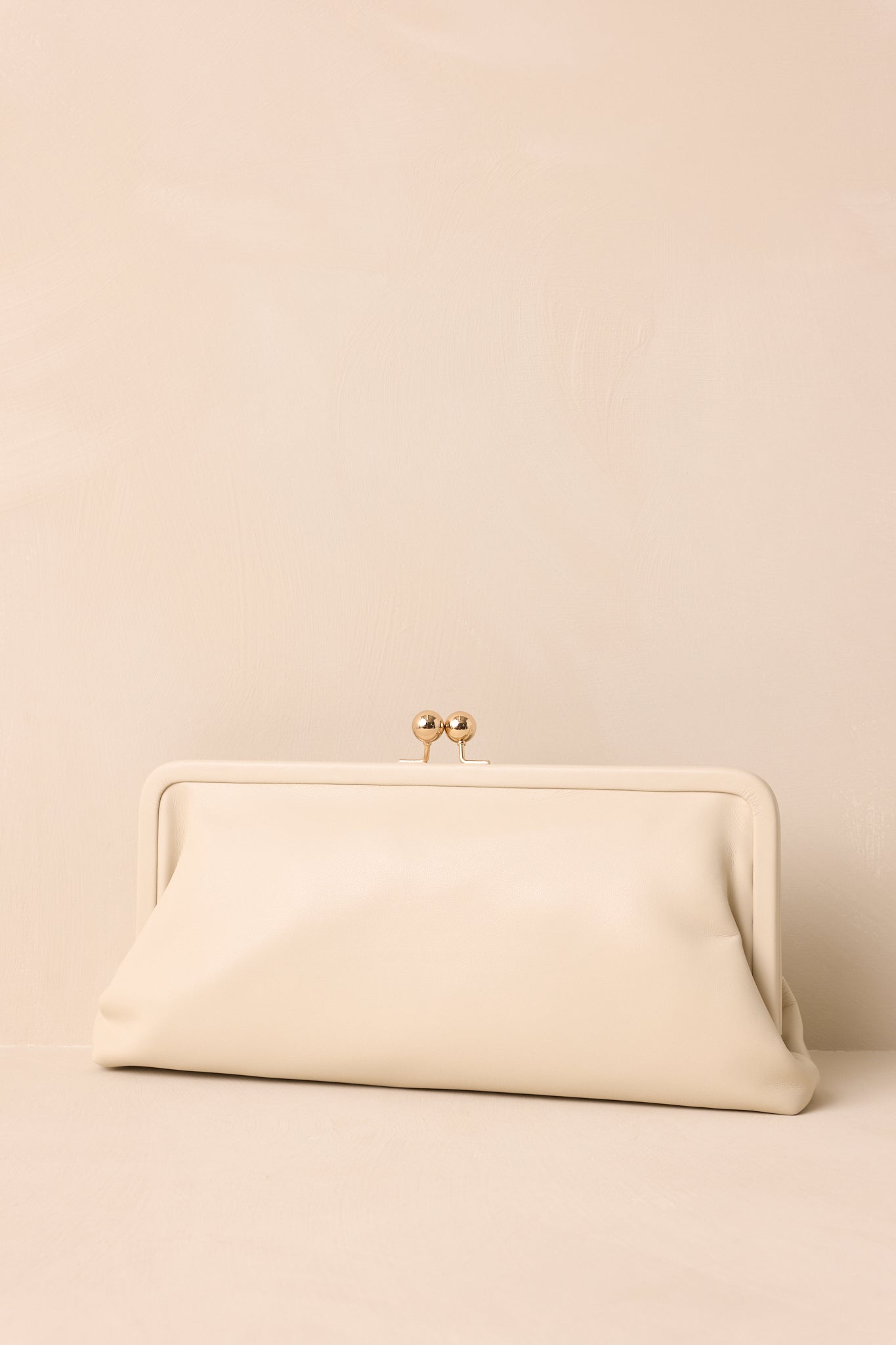 Cropped front view emphasizing the gold kiss-lock closure and structured edges.