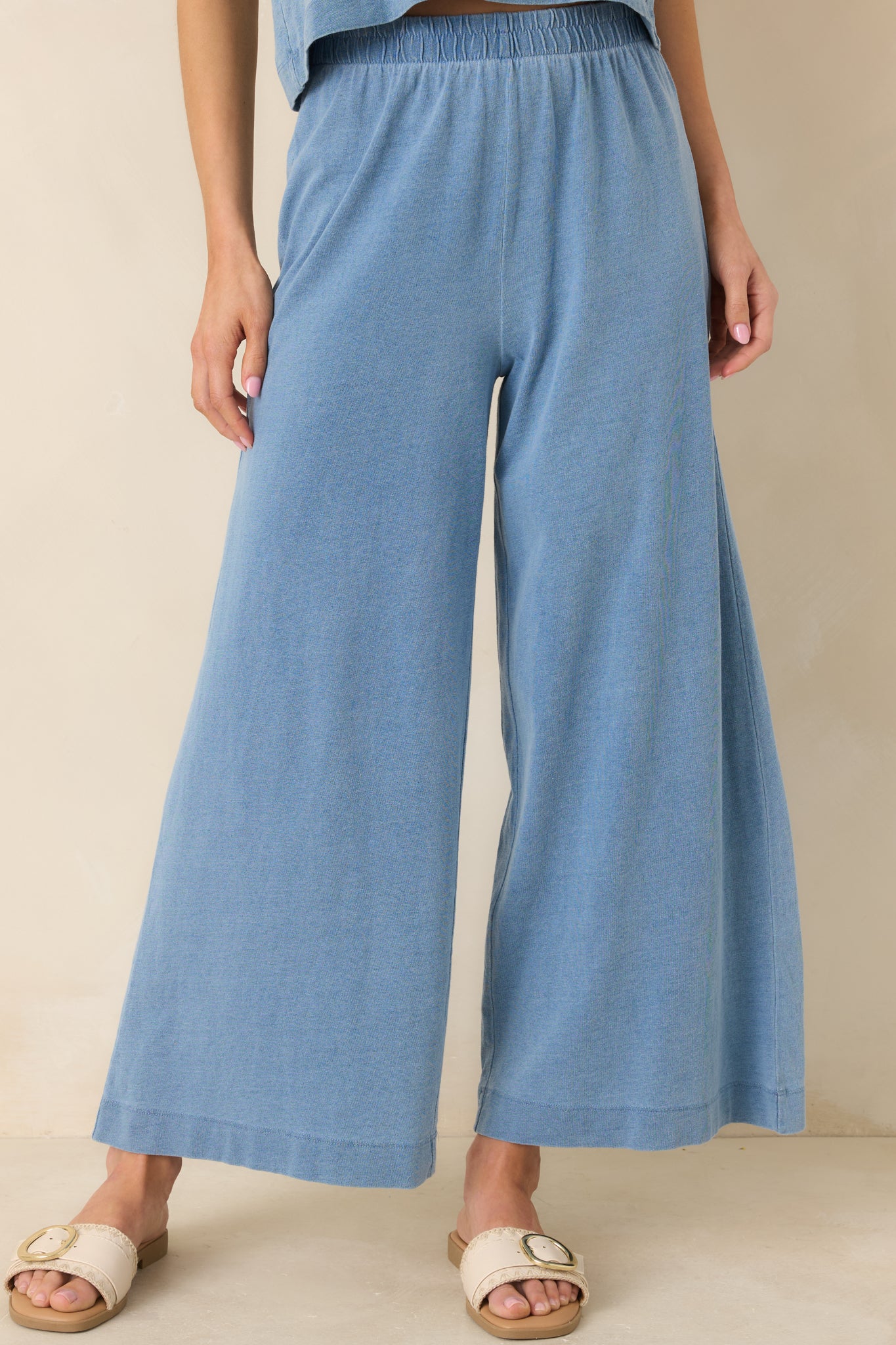 Cropped front view highlighting the elastic waistband and soft cotton knit texture of the indigo pants.