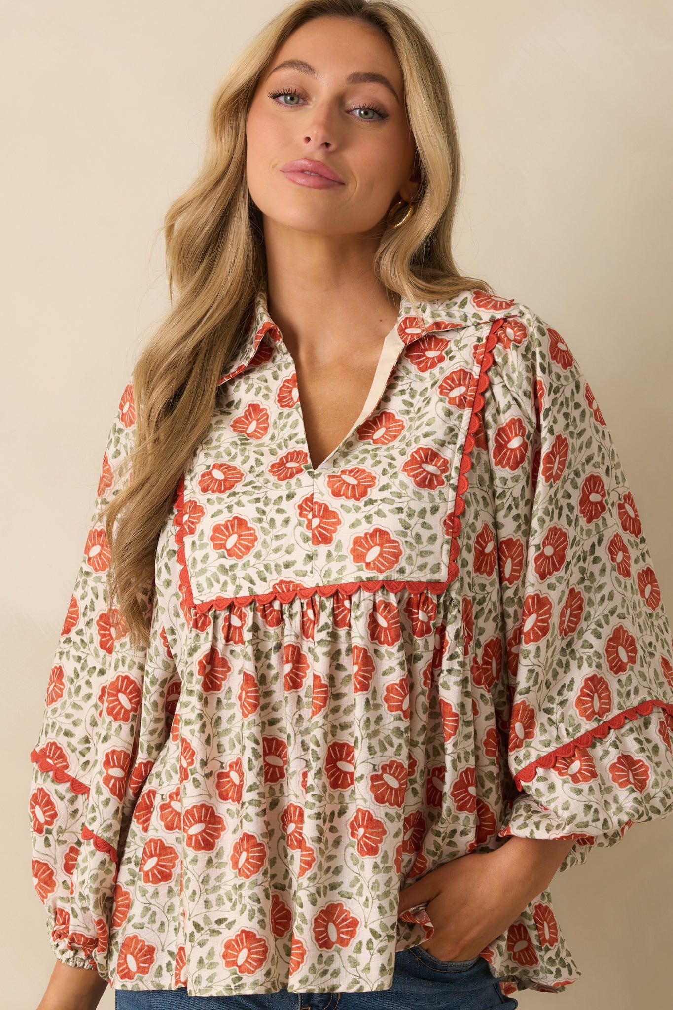 A cropped front view focusing on the collared V-neckline and orange yoke trim.