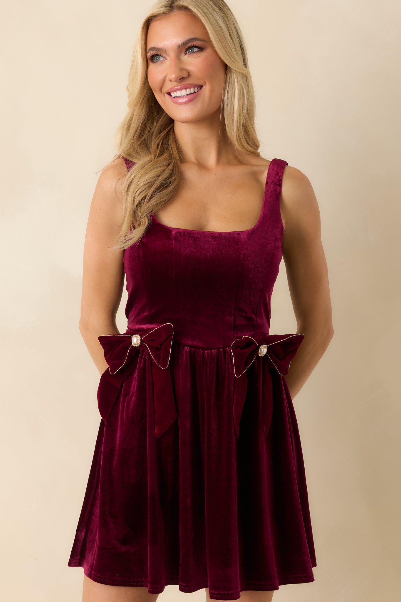Cropped front view emphasizing decorative bow details, square neckline, and wide shoulder straps.