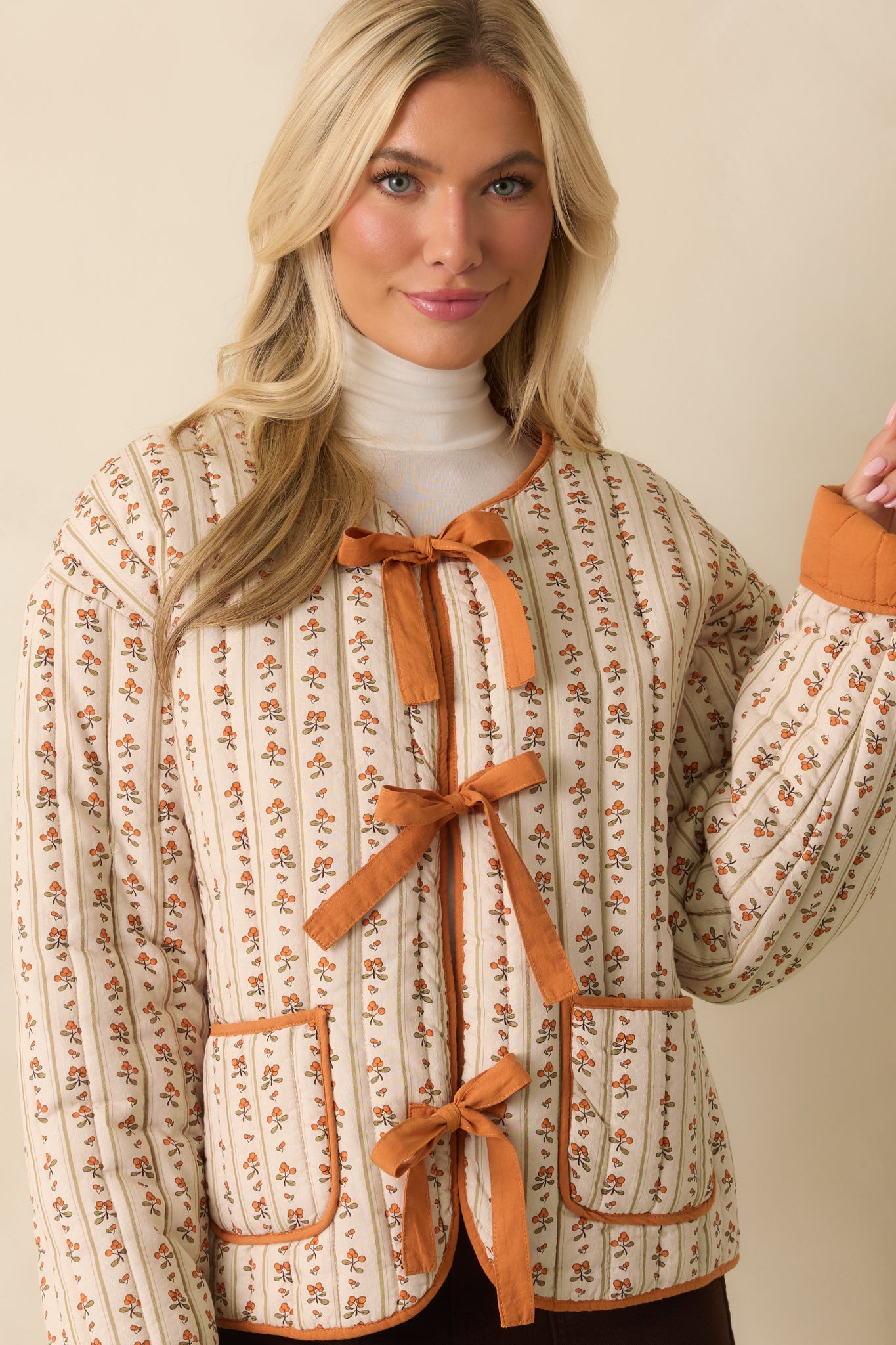 A cropped front view focusing on the self-tie bow closures and orange trim detail.