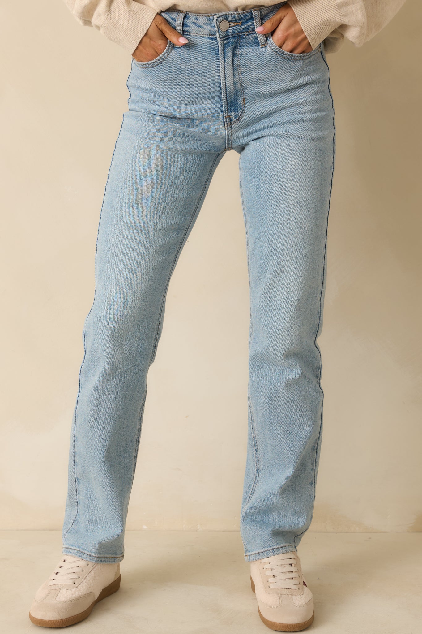 Cropped front view focusing on the waistband, belt loops, and button zipper closure of the jeans.