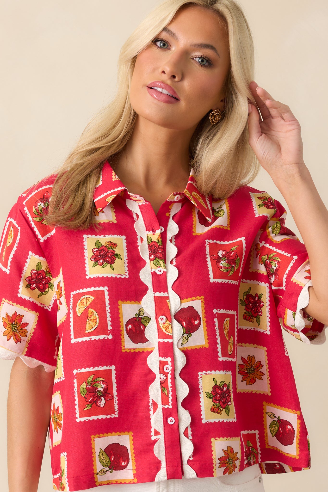 Lower cropped-in image displaying the hemline and relaxed fit of the red top, including the trim along the bottom edge.