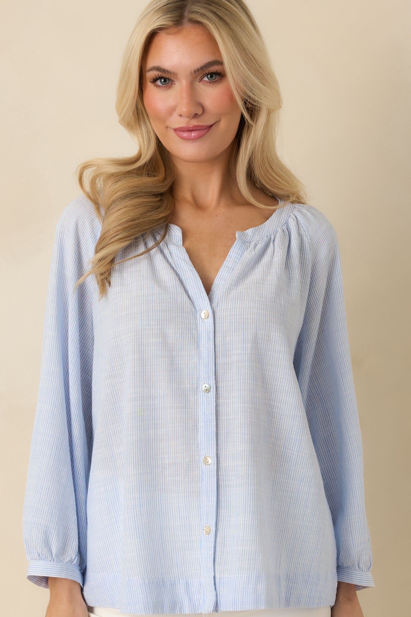 Cropped image focusing on the button-front closure and soft, airy fabric of the blouse.