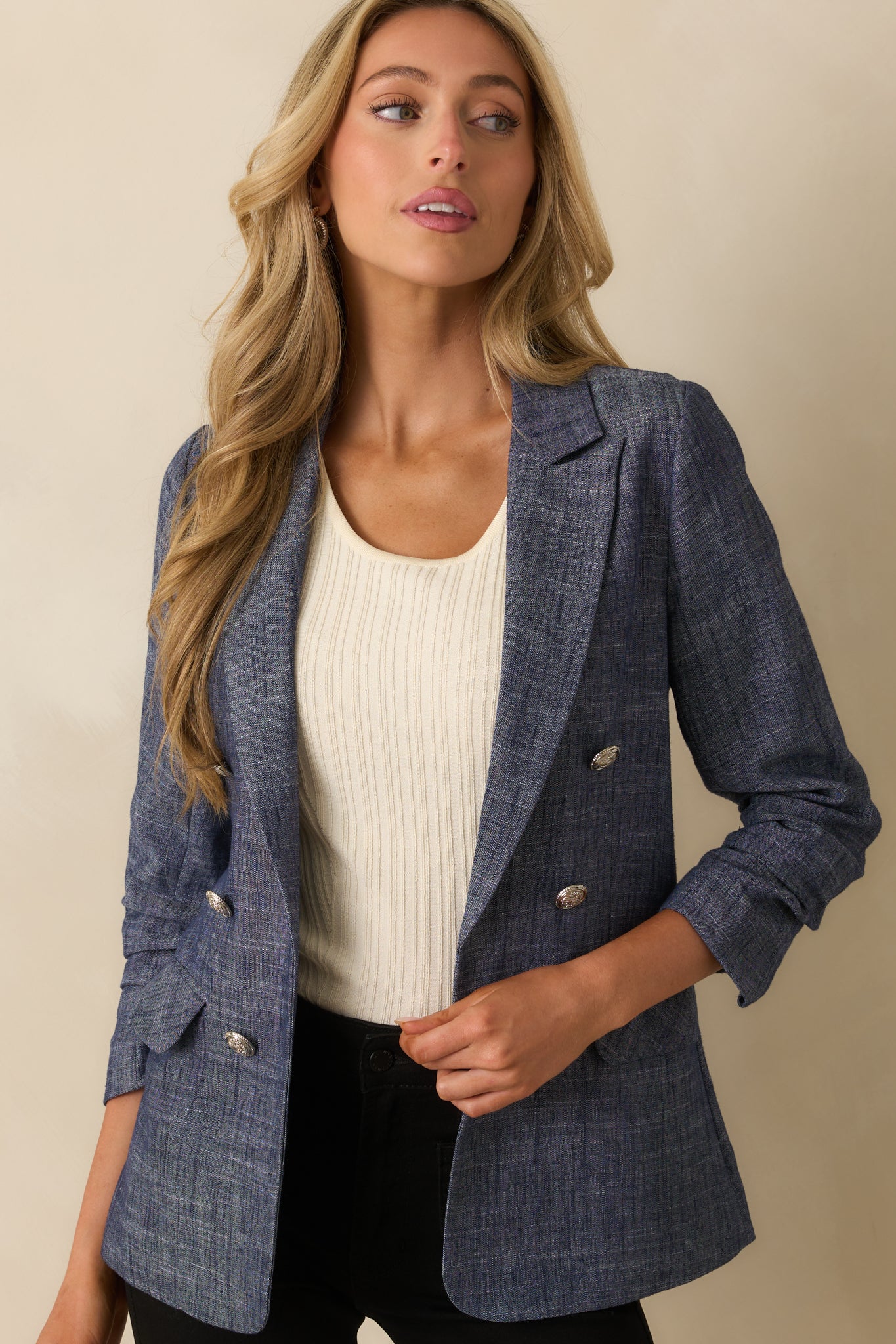 A cropped image highlighting the decorative buttons and navy lining at the opening.