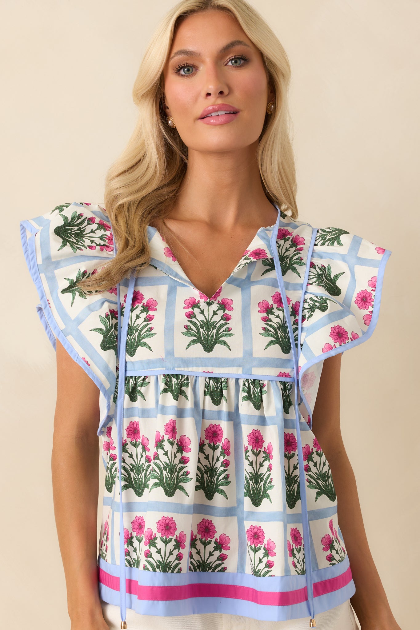 Cropped image showing the arrangement of dark fuchsia floral motifs within the blue grid.