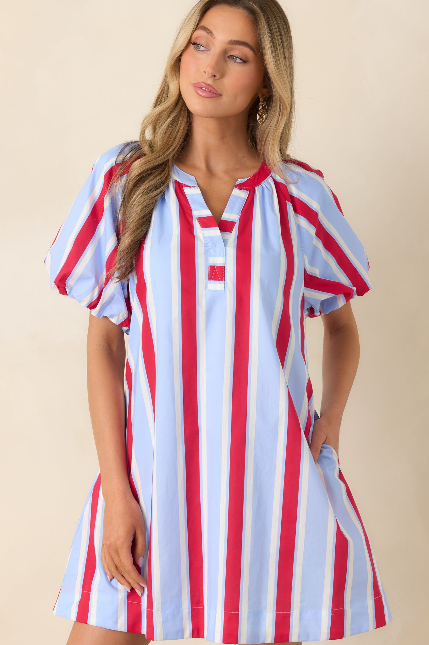 Cropped look at the functional pockets and relaxed silhouette of the red and light blue striped dress