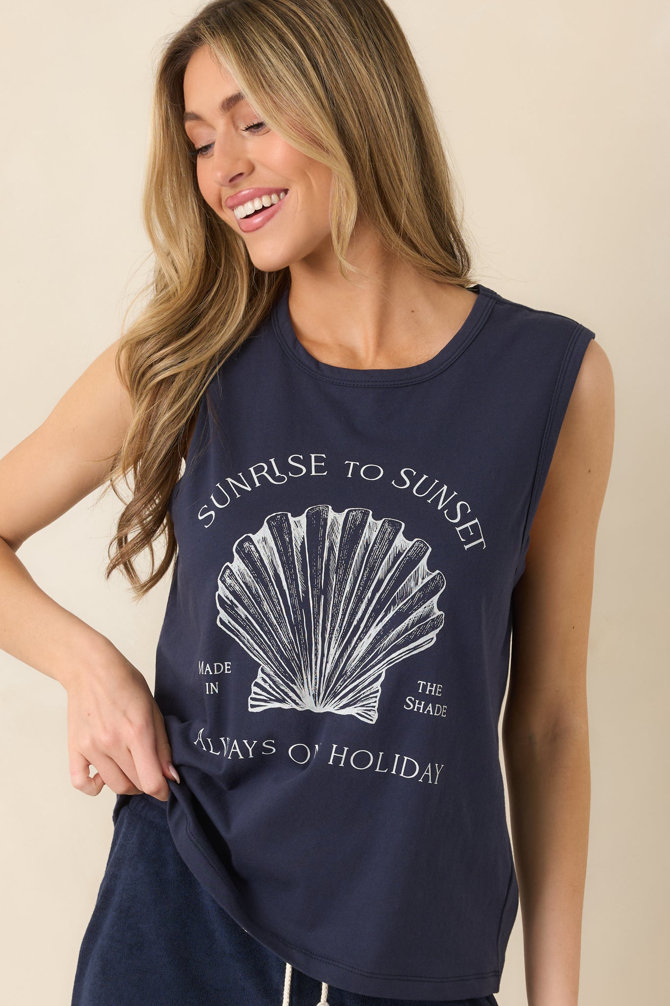 Cropped look at relaxed muscle tank silhouette with shell print and worn-in style text.