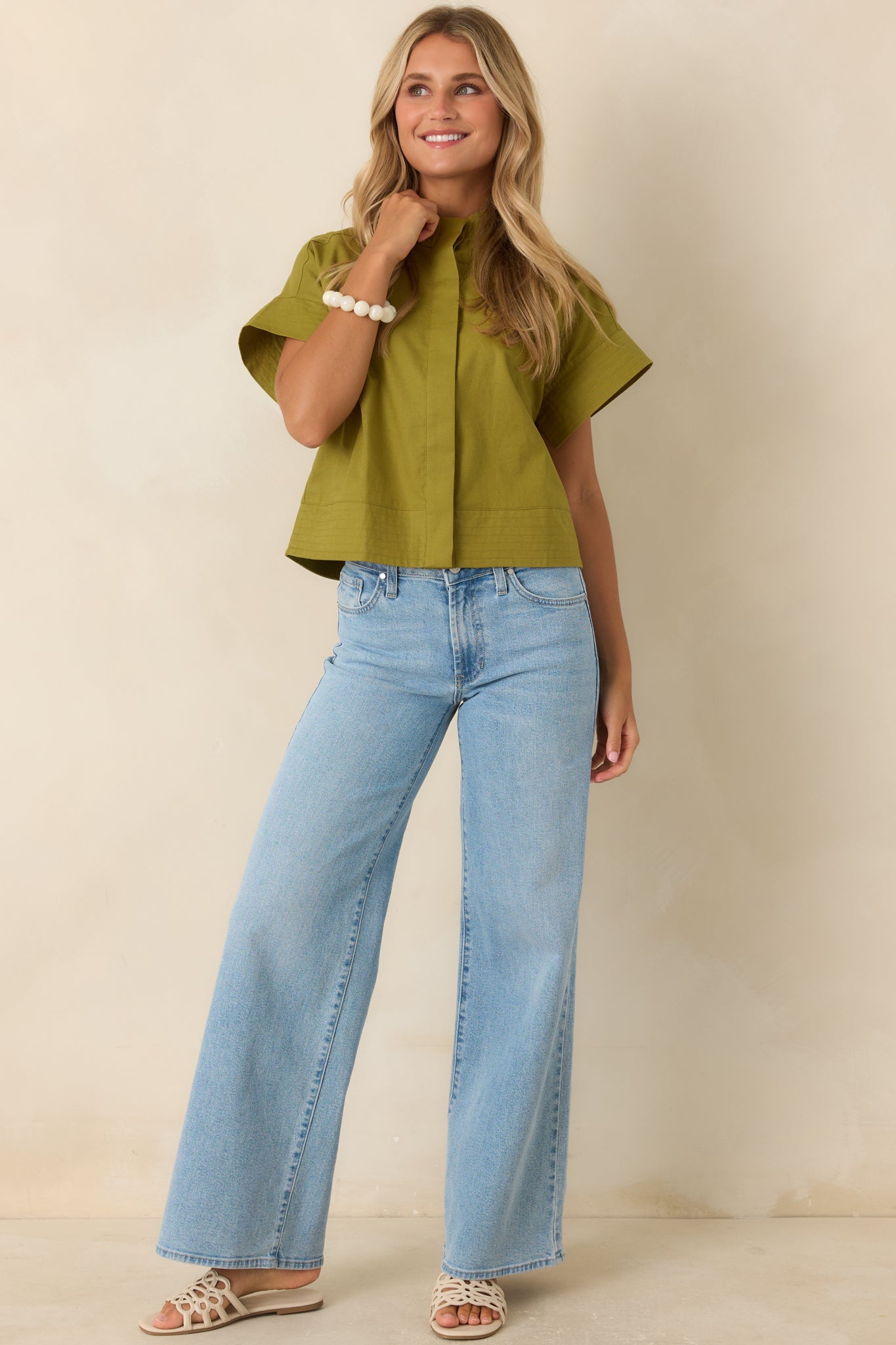 Cropped olive green top crafted from a breathable cotton linen blend with a concealed button-front placket and relaxed drop shoulders.