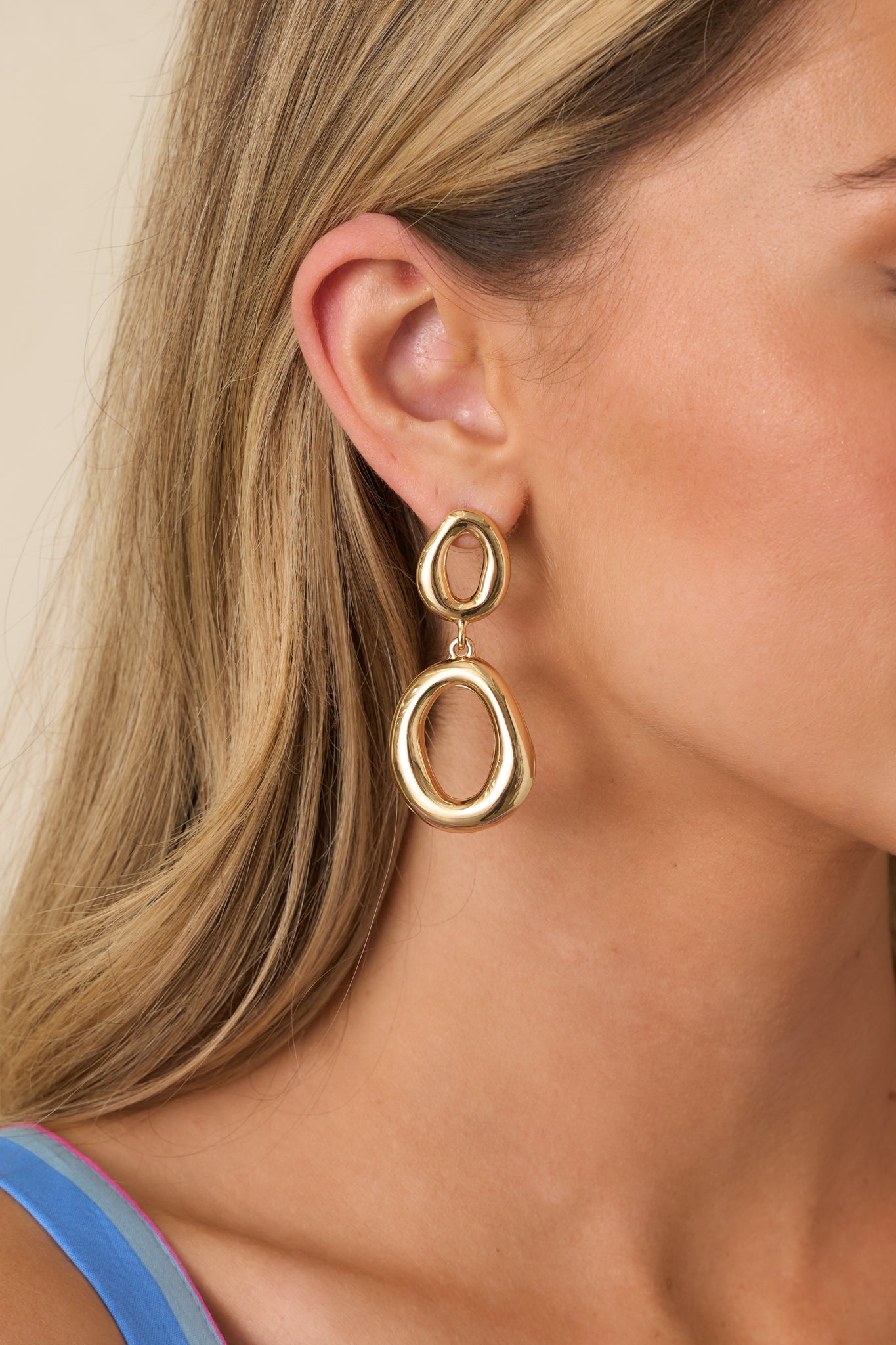 Cropped view showing oval-shaped gold links forming a drop earring design.