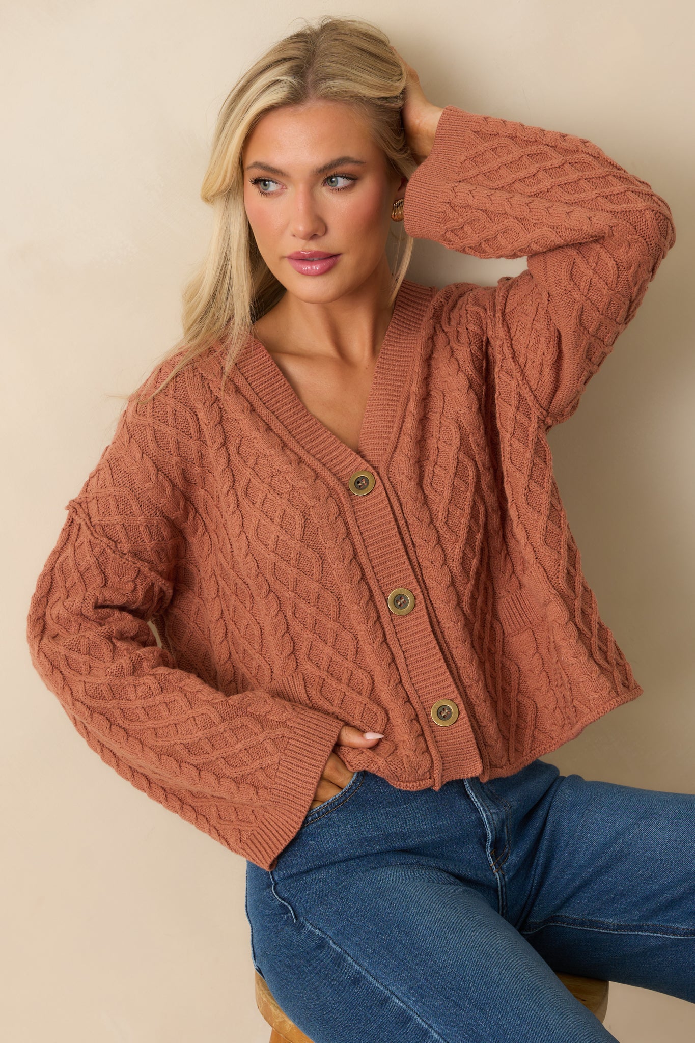 A cropped shot of the terracotta cardigan emphasizing the length of the long sleeves.